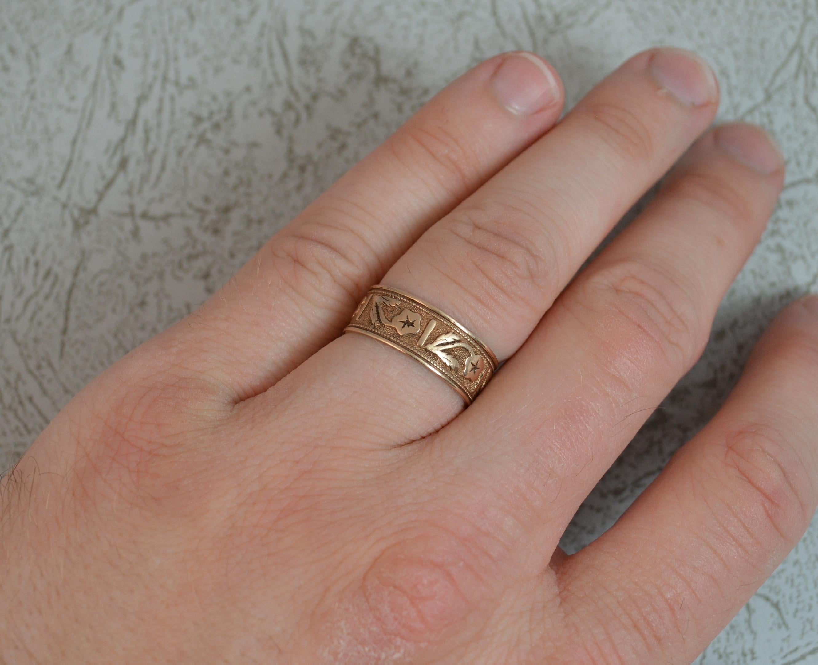 A fine quality antique gold band.
Solid 14 carat rose gold.
7mm wide band throughout.
Designed with a floral engraved finish and blank cartouche.

CONDITION ; Very good for age. Clean band. Crisp pattern. Issue free. Please view photographs.

WEIGHT