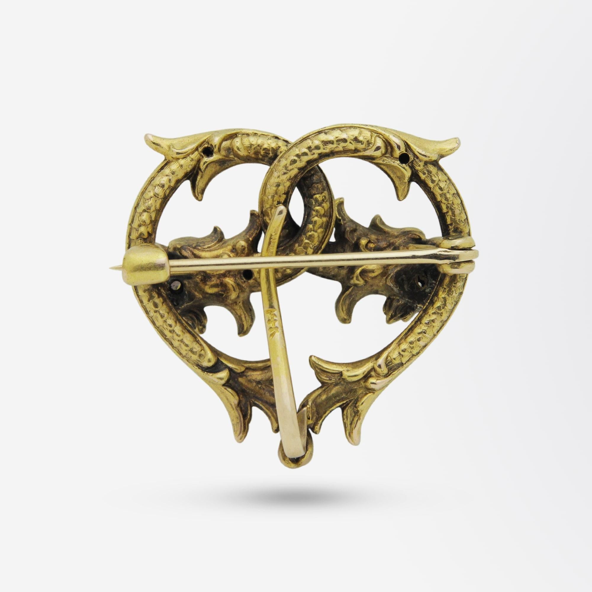 A Victorian brooch pin with hook to the rear to enable a fob watch to hang. The brooch is crafted from 14 karat yellow gold, indicating it is likely American, and is set with peridots and diamonds. The form of the pin is that of two intertwined