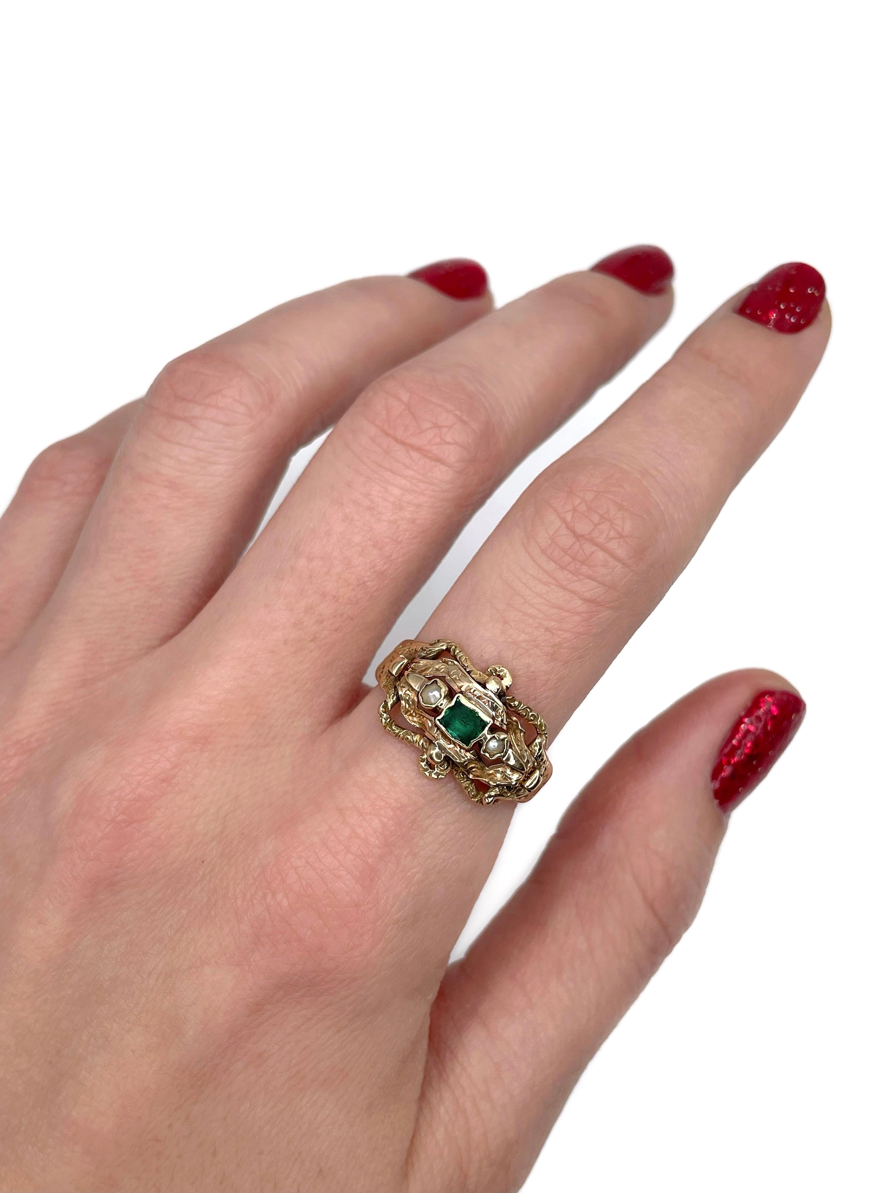 This is a Victorian ring crafted in 18K gold. Circa 1870. 

The piece features 1 emerald and 2 seed pearls. It is highly ornamented. 

Due to its old age the surface of emerald is of average condition.

Weight: 4.04g 
Size: 18.5 (US 8.5)

IMPORTANT: