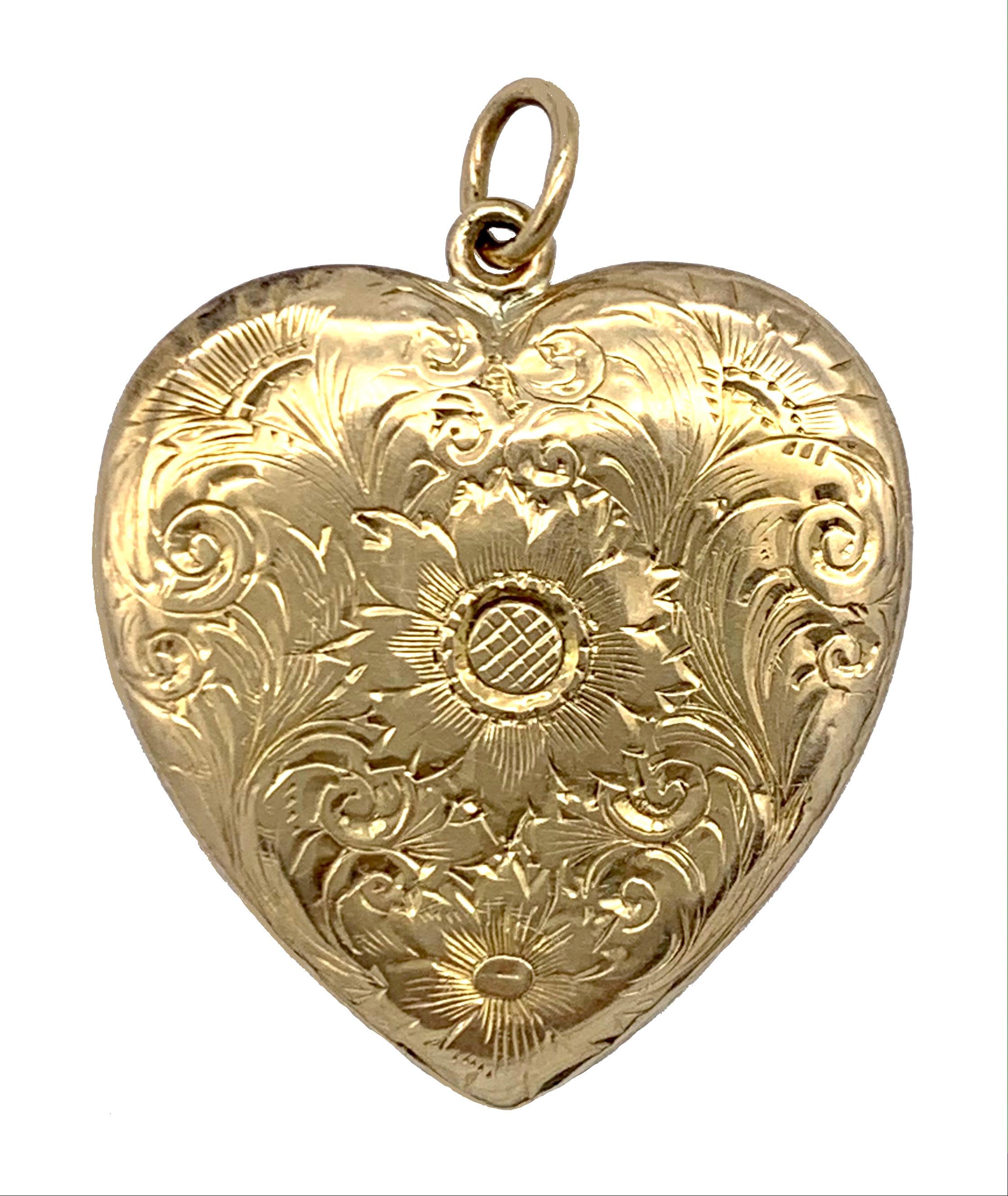 Das elegante viktorianische Herzmedaillon ist reich mit einer großen und einer kleinen Blume, vielleicht einer Sonnenblume, Disteln und Blättern auf Vorder- und Rückseite graviert. Die Blumen sind von einem schönen Rankenwerk umgeben, das das