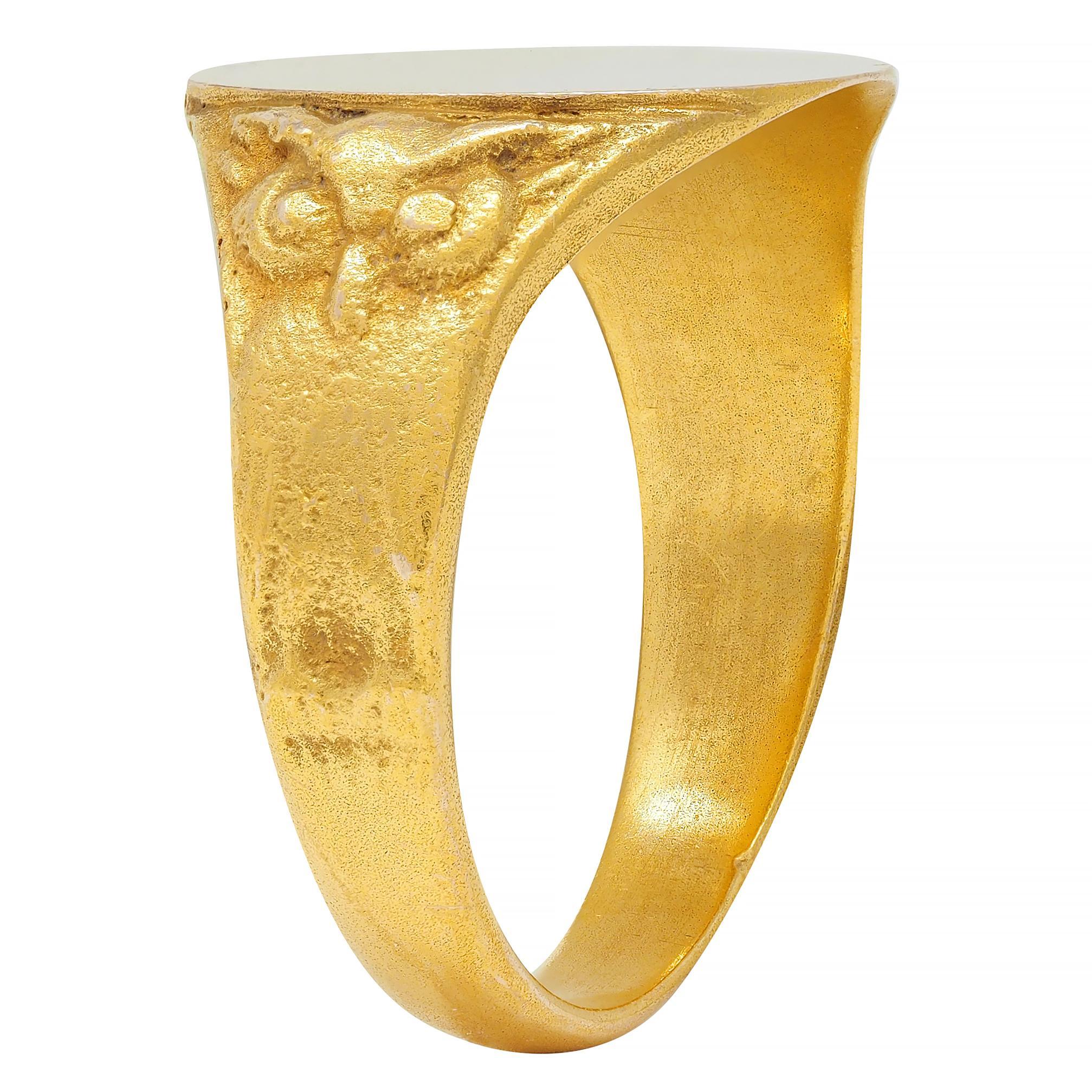 Centering an oval-shaped high polish gold signet face 
Flanked by stylized owl motif shoulders
With grooved details 
Tested as 14 karat gold
With maker's mark
Circa: 1890s
Ring Size: 8 1/2 and sizable
Measures north to south 14.7 mm and sits 2.2 mm