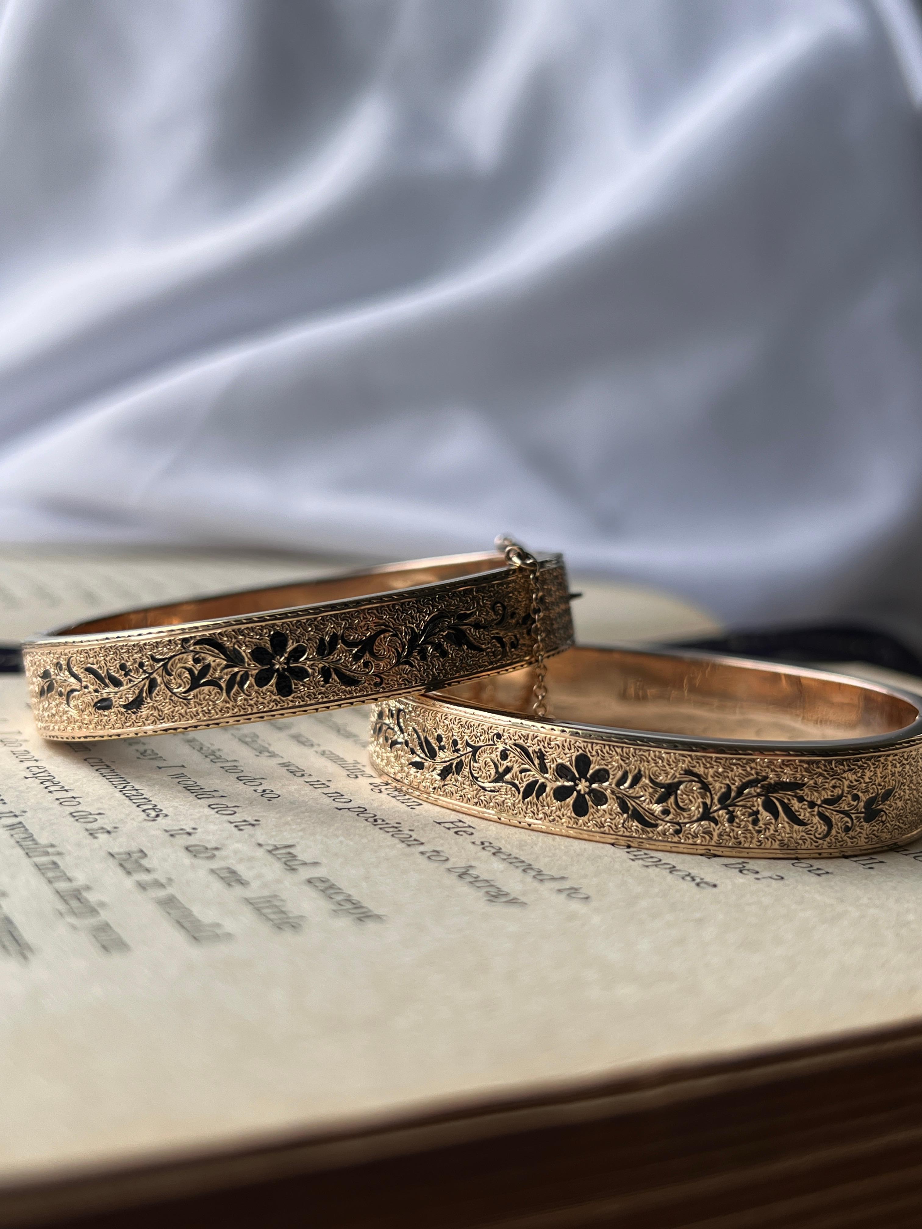 Un excepcional y raro juego de pulseras de boda victorianas Taille d'Épargne de oro amarillo de 14 quilates, exquisitamente decoradas con esmalte floral negro. Cada pulsera está fabricada con una caja de seguridad y un cierre de seguridad, mide 9,5