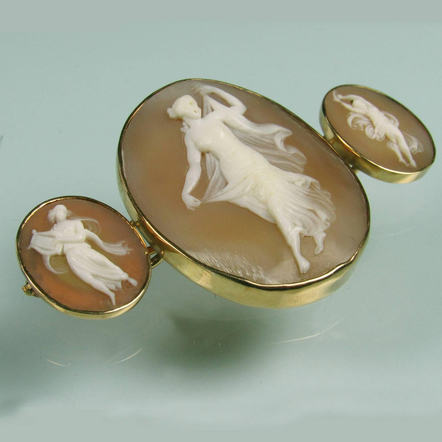 Exceptional Victorian 14kt Yellow Gold Triple Shell Carved Cameo Brooch.  Central cameo depicting a full female figure with flowing garment, flanked by two smaller cameos depicting female musicians.   Signed on verso illegibly and clasp marked