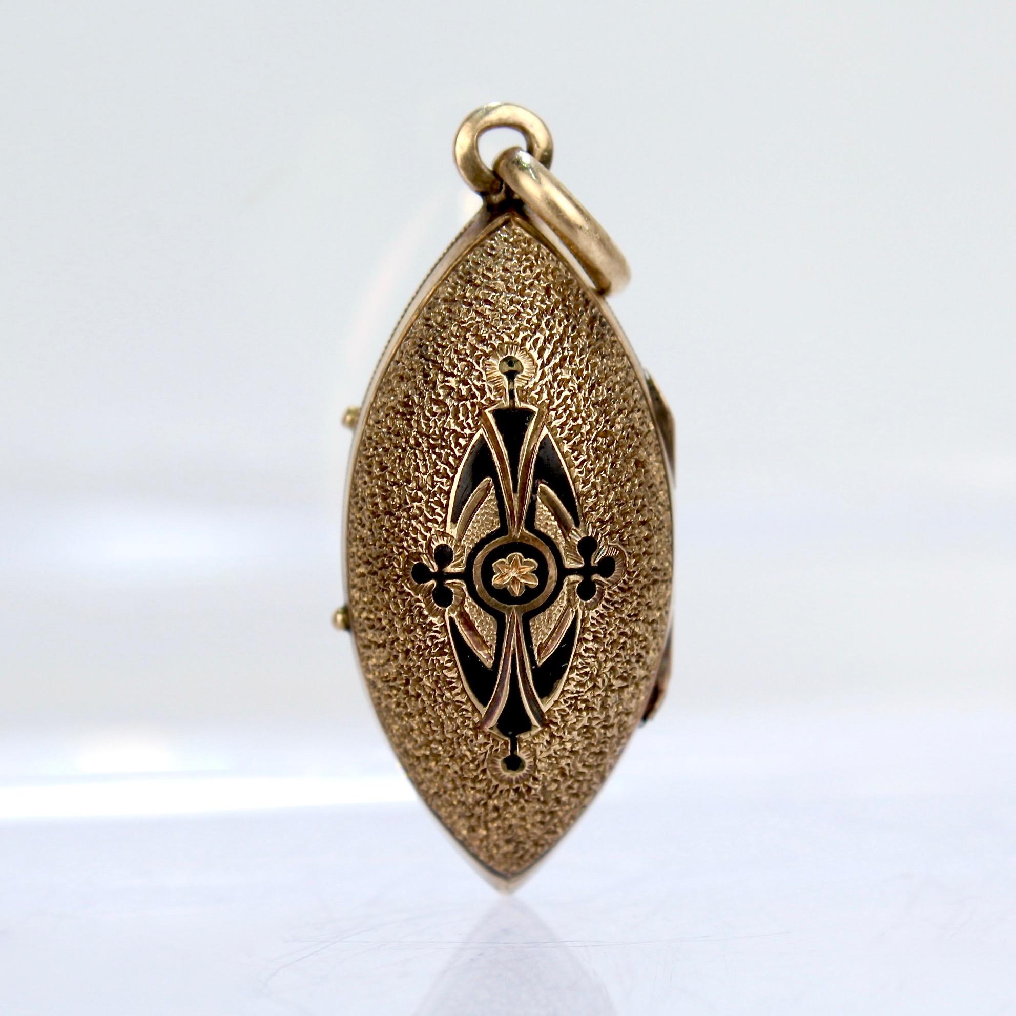 A fine Victorian 14k gold mourning locket.

The locket is fashioned as a pendant with finely textured 14K gold and black enamel to the front and a back section that houses a lock of hair. 

The locket is shaped like a football or a prolate spheroid