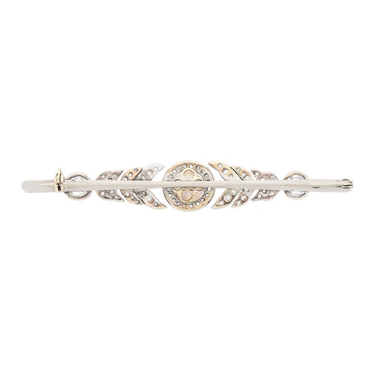 This lovely brooch features diamonds and pearl arranged in a delicate design. The natural pearl has great lustre. Two 0.50 carat old cut diamonds sit on the ends of the brooch, and an additional 0.40 carats of rose cut diamonds are set into the