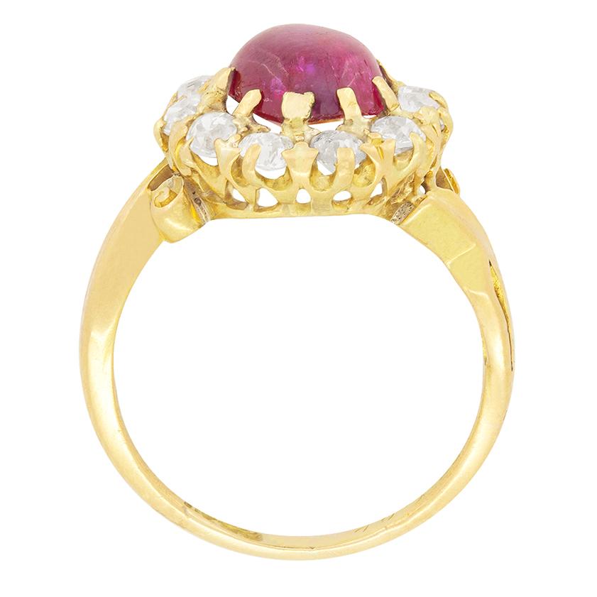 In der Mitte dieses viktorianischen Rings befindet sich ein schöner Rubin im Cabochon-Schliff. Der Rubin wiegt 1,40 Karat und ist von einem Halo aus Diamanten im Altschliff umgeben. Sie wiegen insgesamt 0,55 Karat und haben eine geschätzte Farbe von
