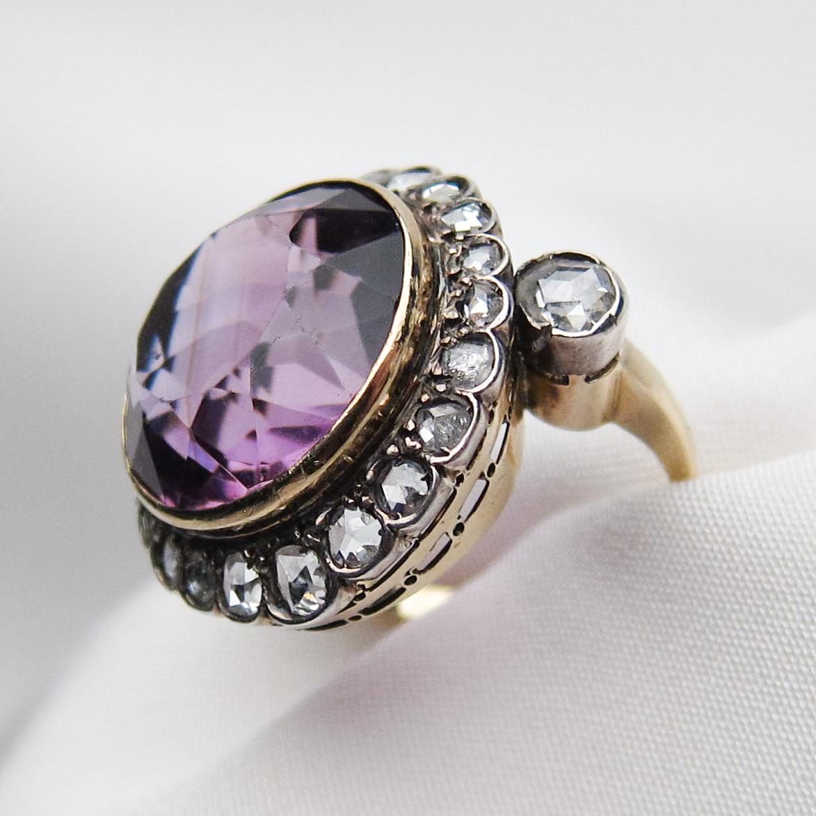 Circa 1880. This lovely Victorian ring features an awesome 14.29 carat mixed-cut natural amethyst set in silver-topped 18KT gold. Surrounding the amethyst and accenting the shoulders of the ring are 24 rose-cut diamonds weighing 1.24 carats total