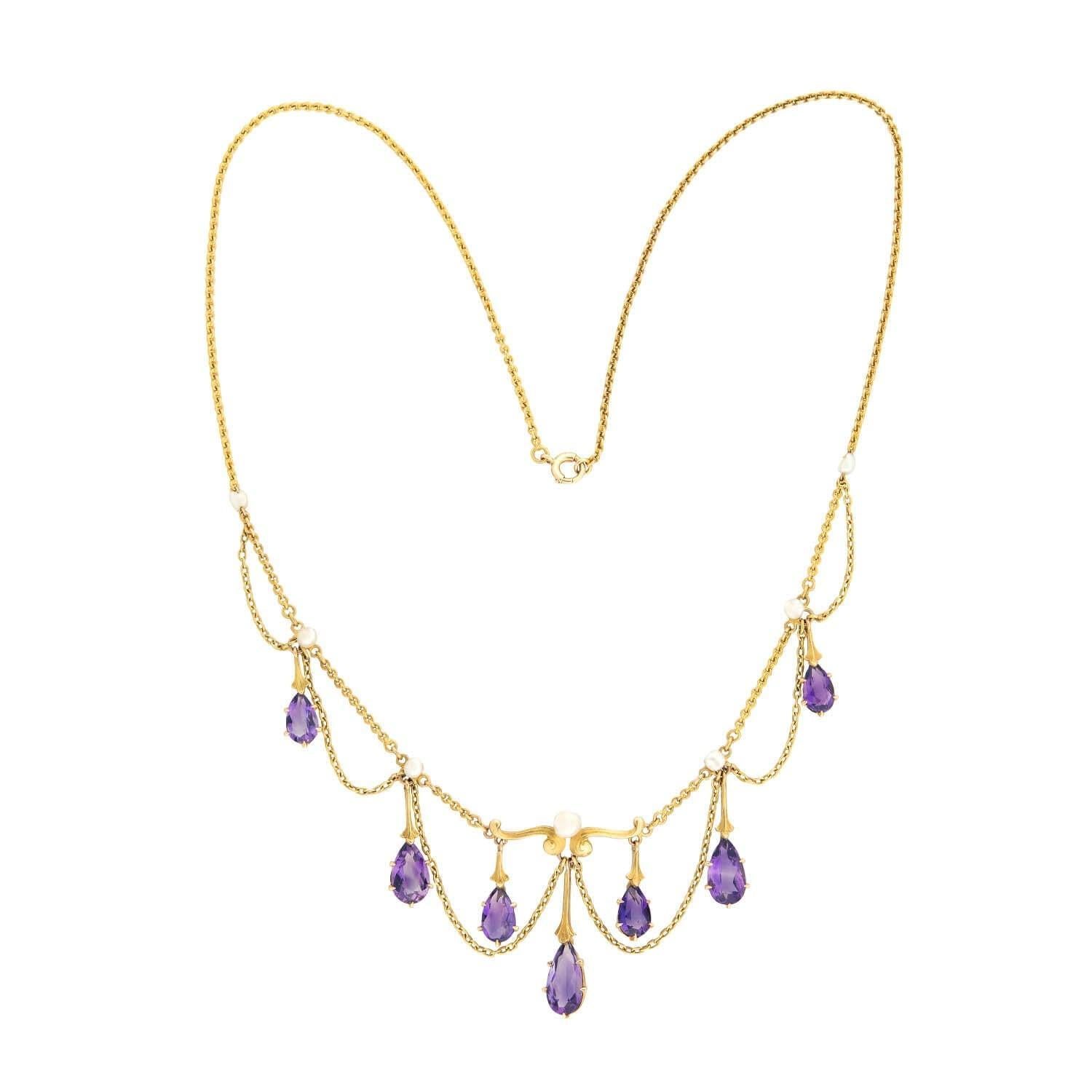 Un magnifique collier feston de l'époque victorienne (ca1880) ! Cette magnifique pièce présente 7 améthystes en poire graduées, suspendues à une chaîne en or 14kt dans un style feston. Les liens en améthyste sont magnifiquement facettés et ont une