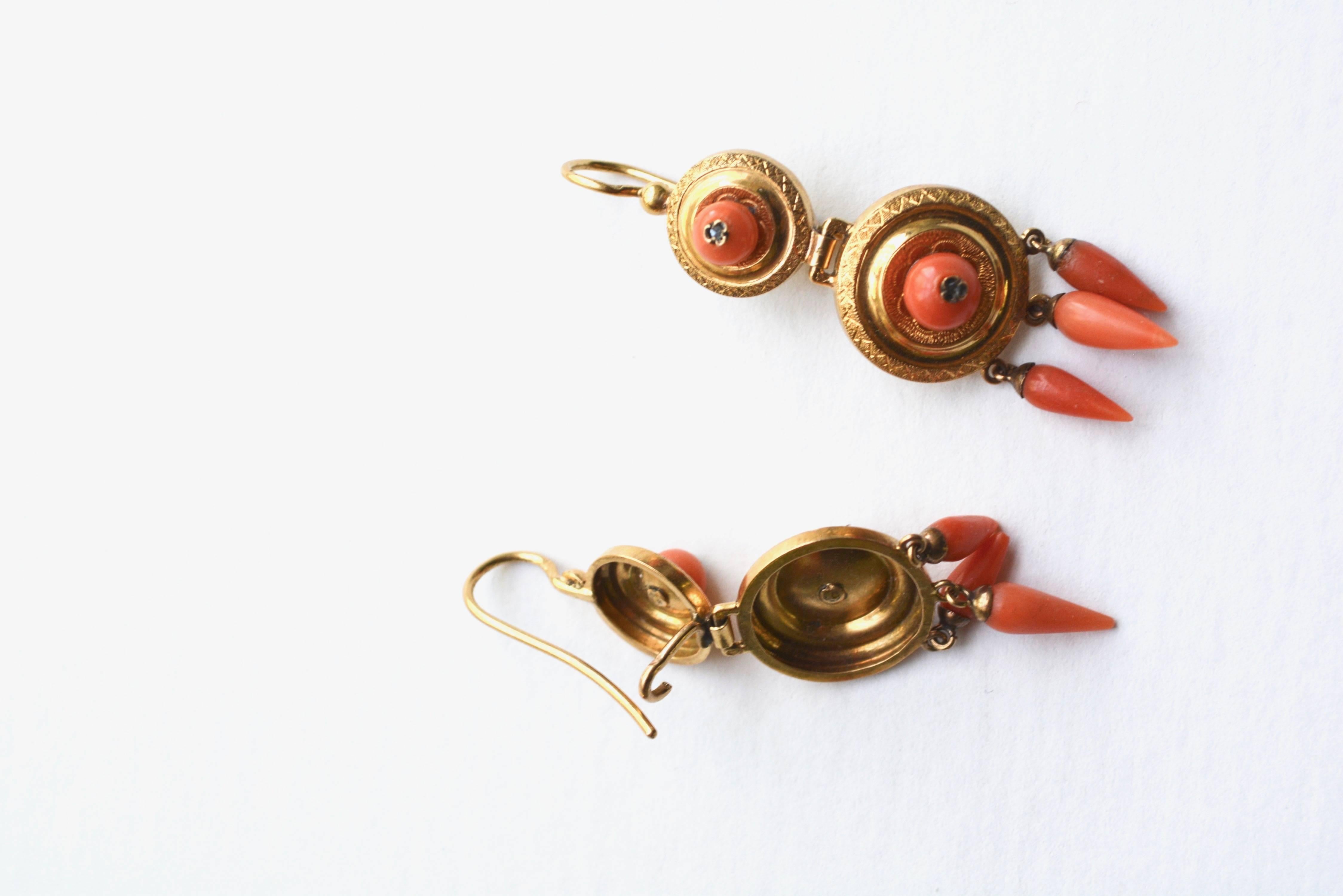 Gold and coral Victorian hook earrings with European hallmarks, illegible mark which appears to be either a lion or crab. Tiny diamond accents. Mild wear to one coral tip with has been chipped. Could be smoothed, but not noticeable on the ear.
