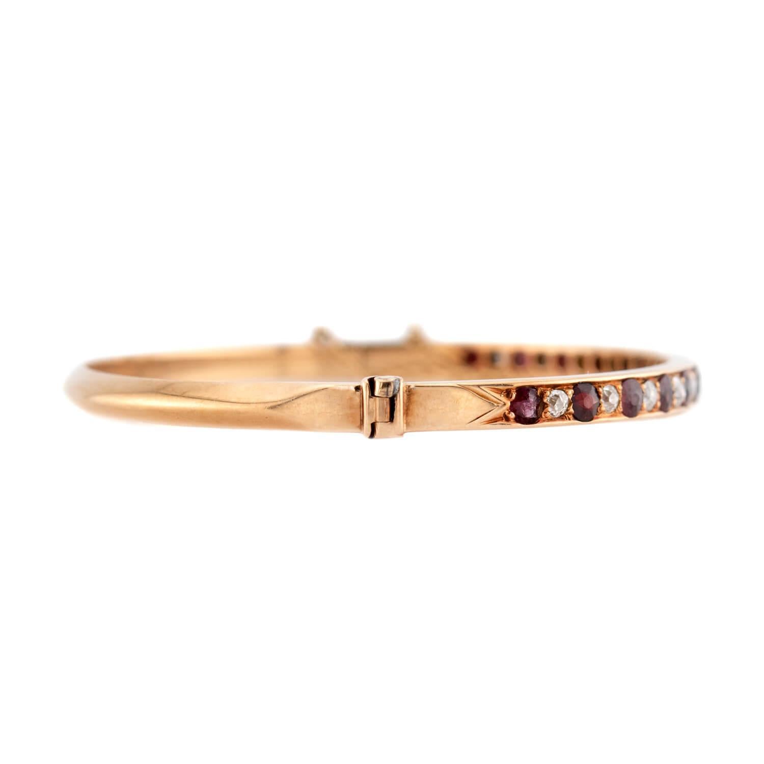 A fabulous diamond and garnet bangle bracelet from the Victorian (ca1880s) era! Crafted in 14k yellow gold, the front half of this bangle features a row of alternating diamonds and garnets. The diamonds, which are all old mine cuts, have an