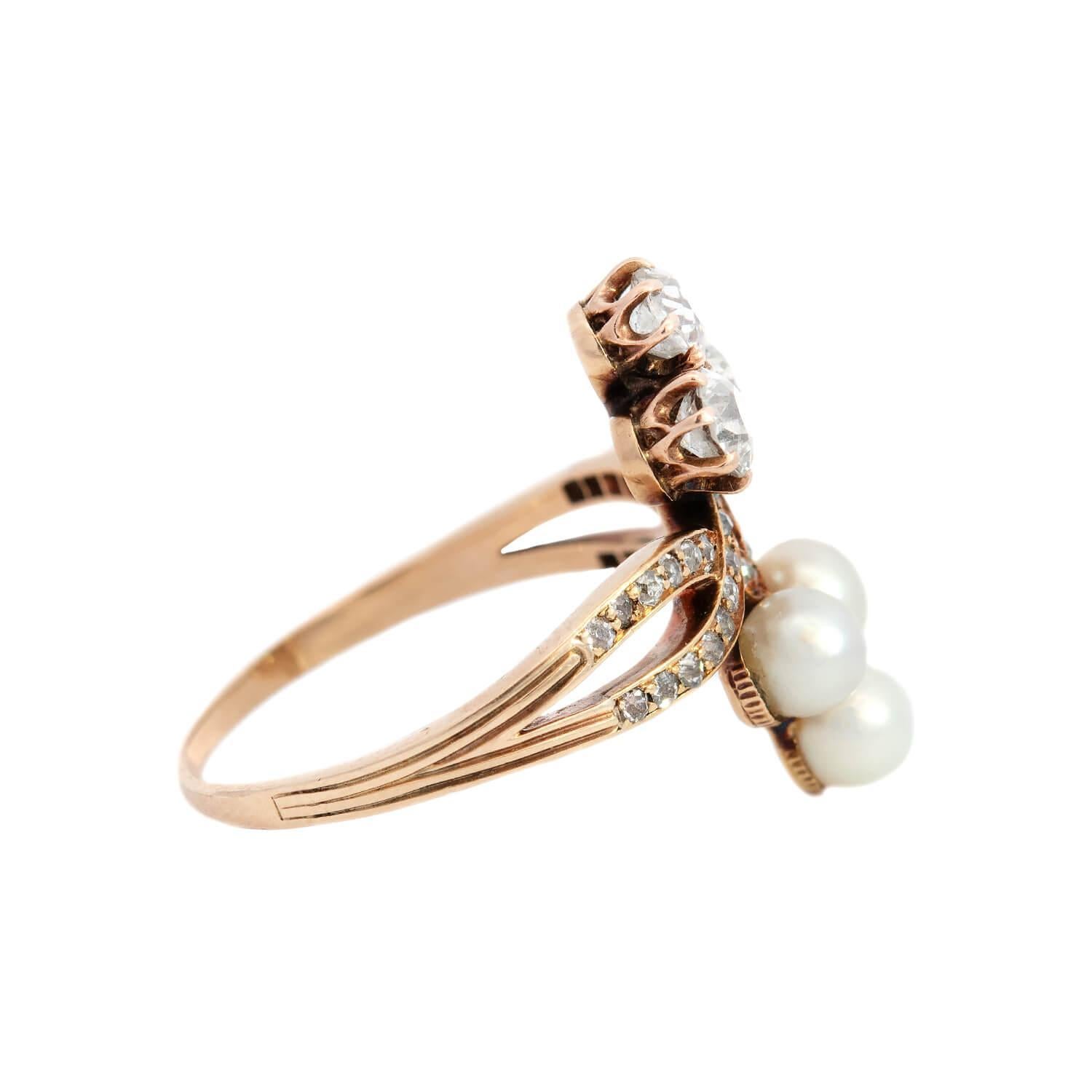 A stunning diamond and pearl double trefoil ring from the Victorian (ca1880s) era! Crafted in 14k yellow gold, the piece features an elaborate centerpiece, which features three, bezel set pearls arranged in a trefoil motif. Parallel to the organized