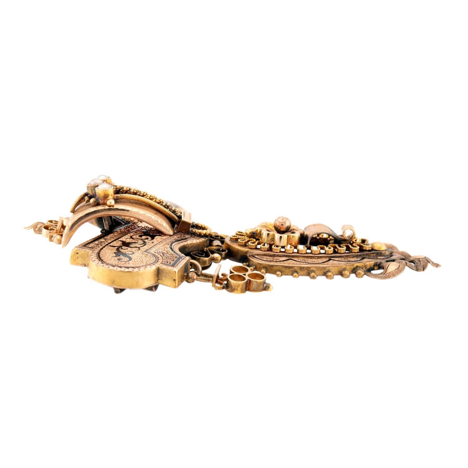 A fabulous pin/pendant from the Victorian (ca1880s) era! Crafted in rosy 14k gold, the top of this pendant features an elaborate plaque, which is decorated with twisting wirework, scrolling-motifs, black enameling, and small three-dimensional balls.
