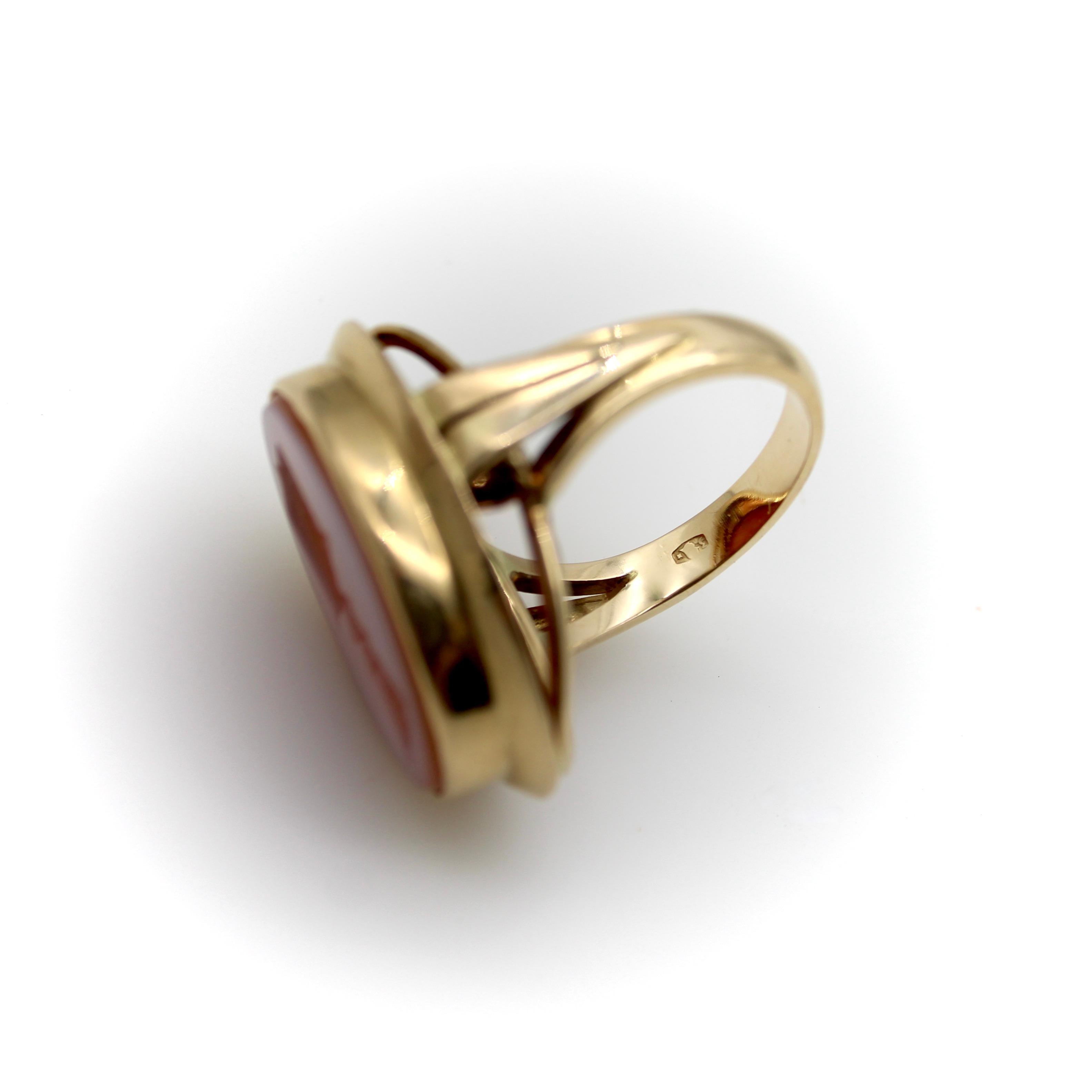 Set in 14k gold, the banded agate intaglio ring is hand-carved with a unique image: a shield topped by a knight’s helmet and a plume of feathers. The shield contains a six-pointed star and a half-moon, a wonderfully theatrical image. The banded