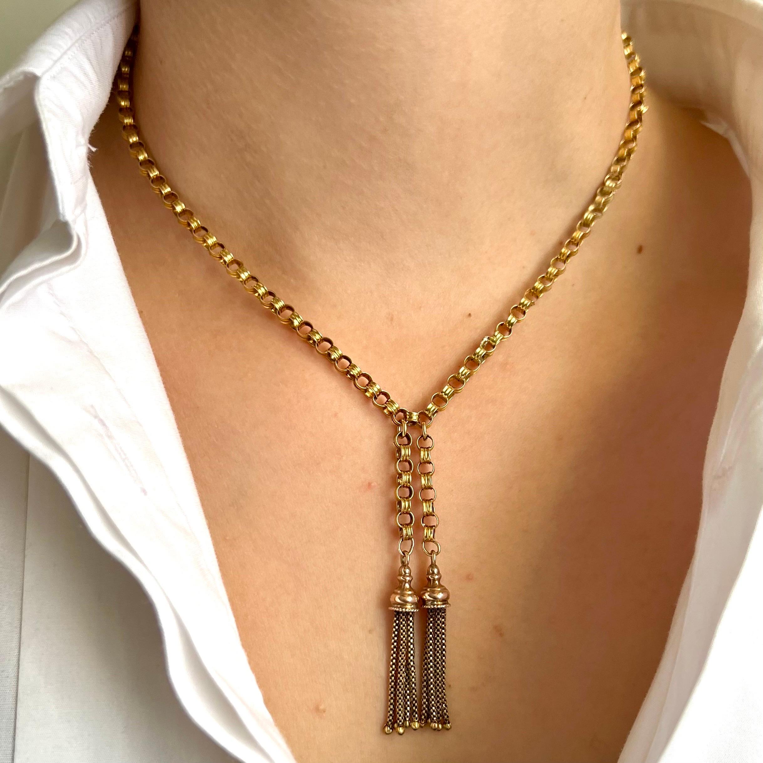 This is an antique Victorian gold link belcher chain necklace set with two dangling tassel pendants. Each round link has a polished decorative grooved link woven together into this gorgeous antique strand. The belcher chain necklace is made of 14