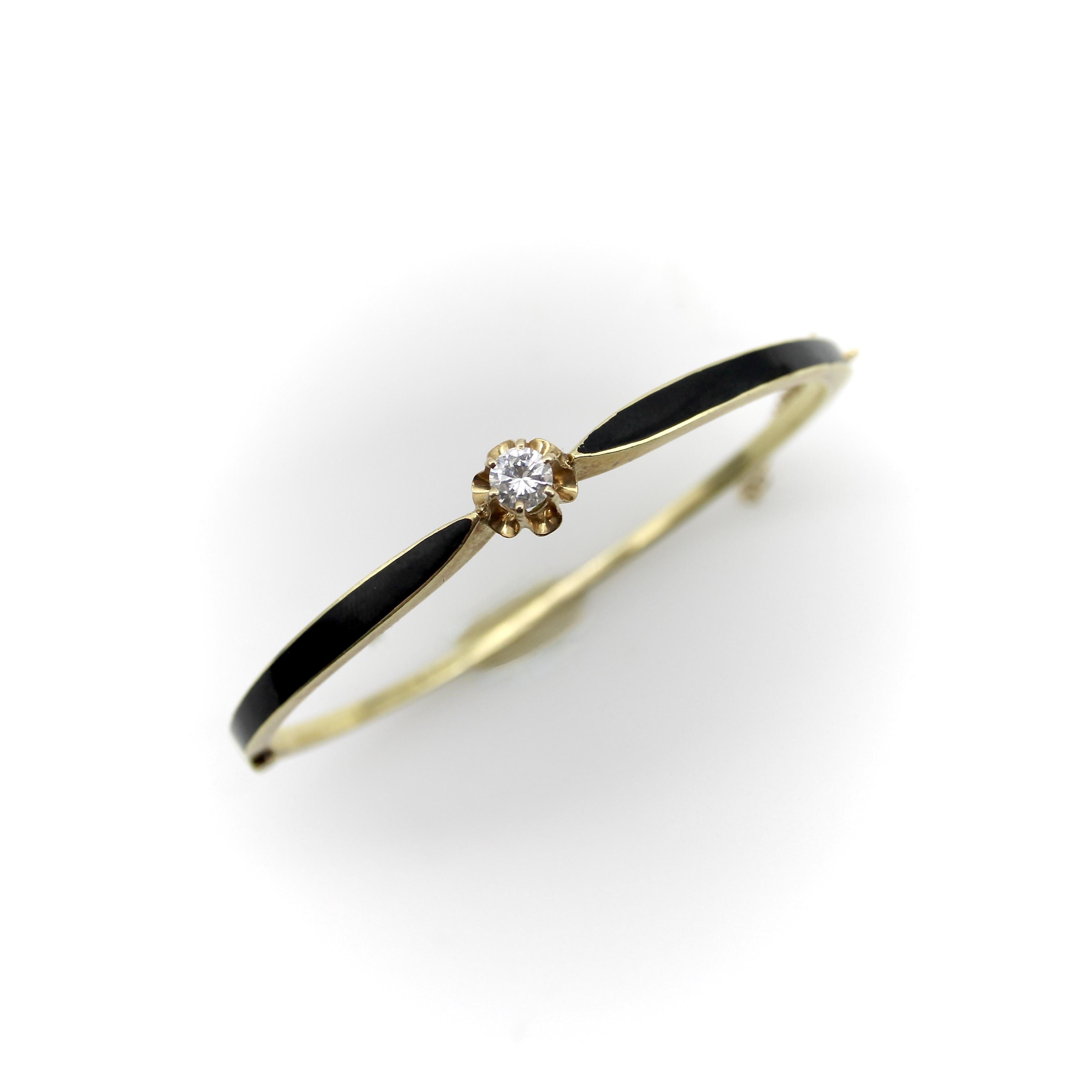 This 14k gold Victorian bracelet has a line of black enamel that comes to a point where it holds up a round brilliant cut diamond in a buttercup mount. The black enamel adds a sharp pop of color that stands out against the wrist, and the pointed tip