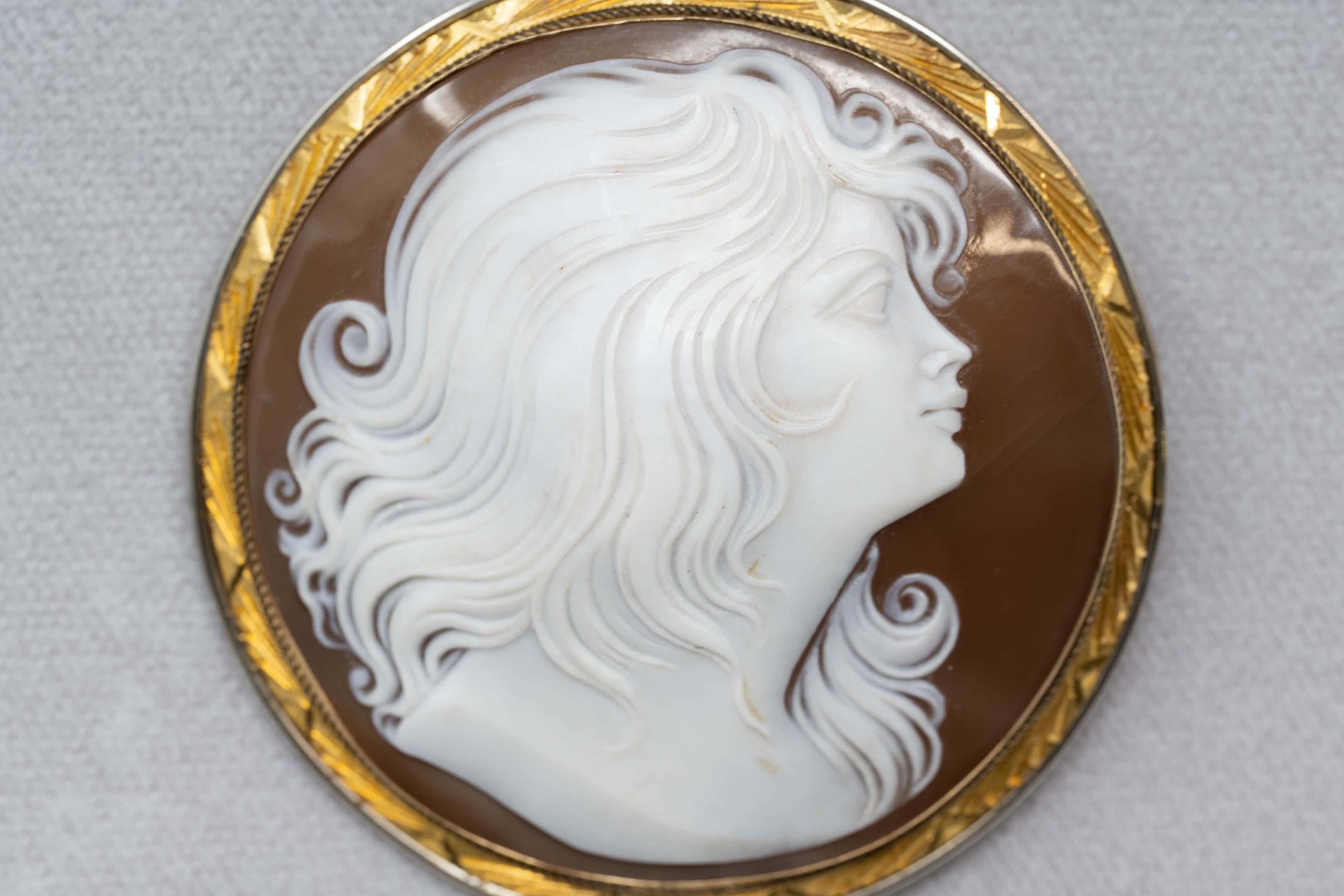 Victorian 14k gold and carved cameo brooch pendant of young woman. Stamped 14k on the back, measures 55 mm in diameter. Weighs 23.5 grams.
