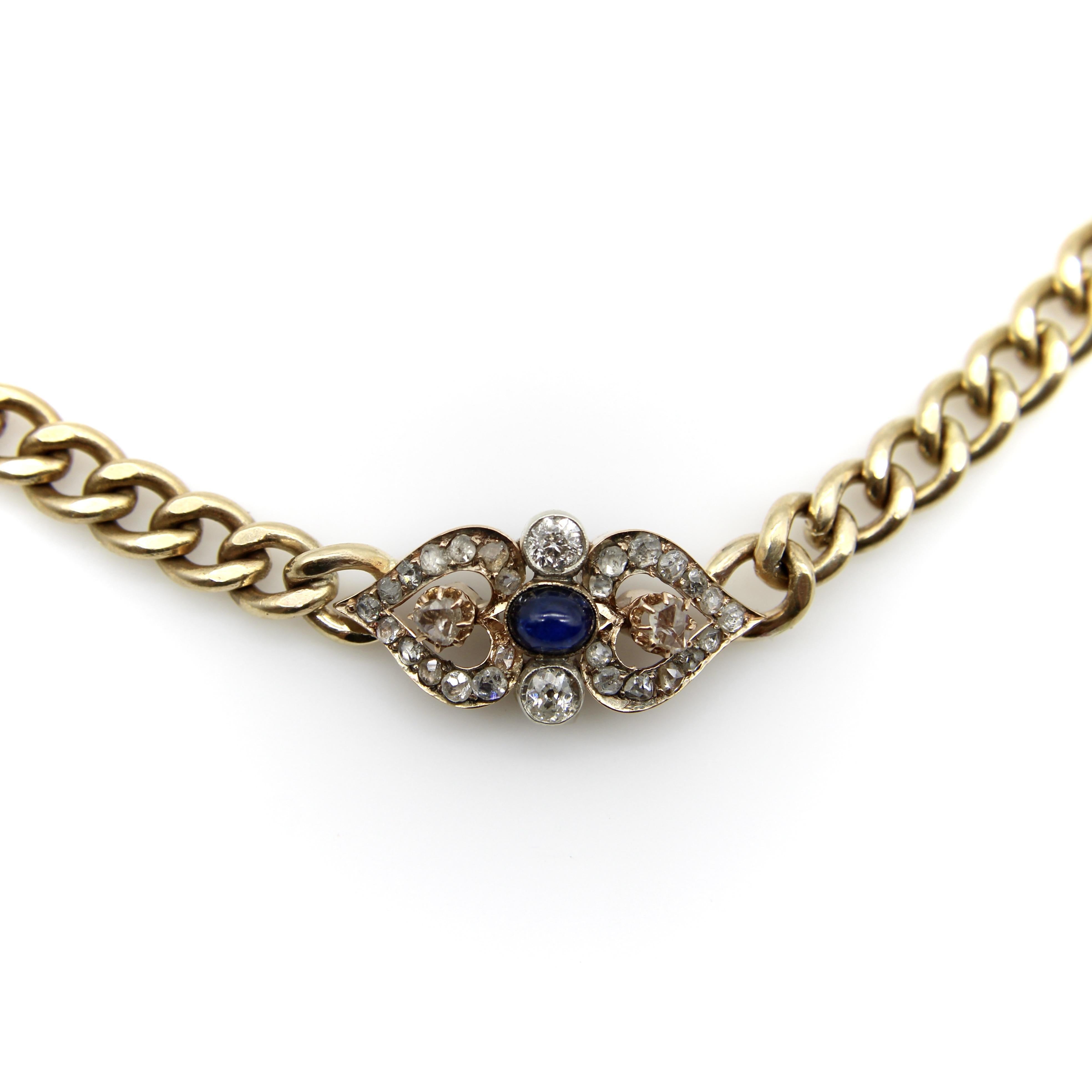 La pièce maîtresse de ce collier victorien en or 14k est un magnifique élément de diamant et de saphir composé d'un diamant taille rose, d'un diamant taille européenne et d'un saphir cabochon. La pièce est symétrique et semble présenter deux cœurs