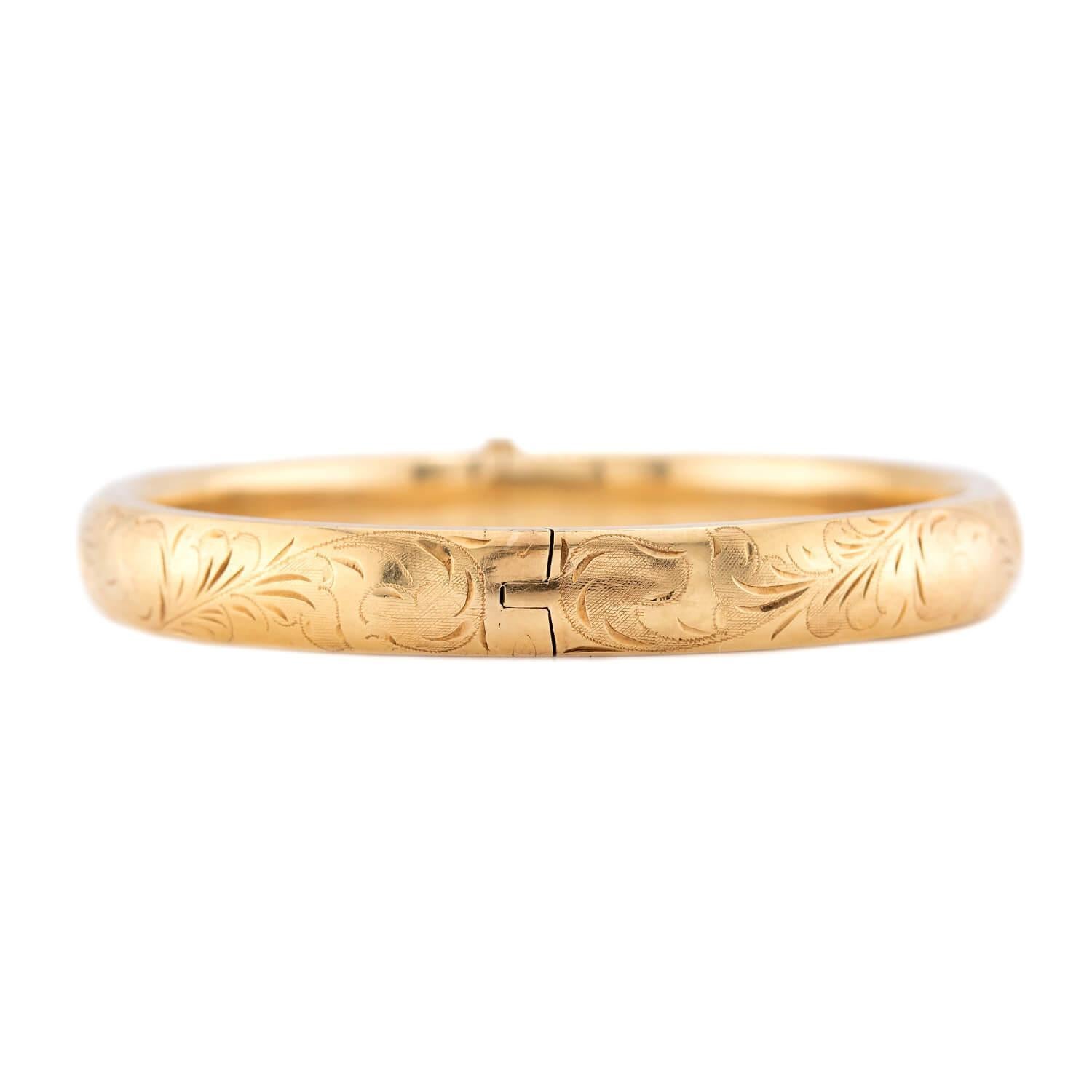 Questo splendido braccialetto bangle di epoca vittoriana (ca. 1880) è davvero senza tempo! Realizzato in vibrante oro giallo 14k, la superficie di questo elegante braccialetto è decorata con graziose incisioni a fogliame e motivi a scorrimento. Il