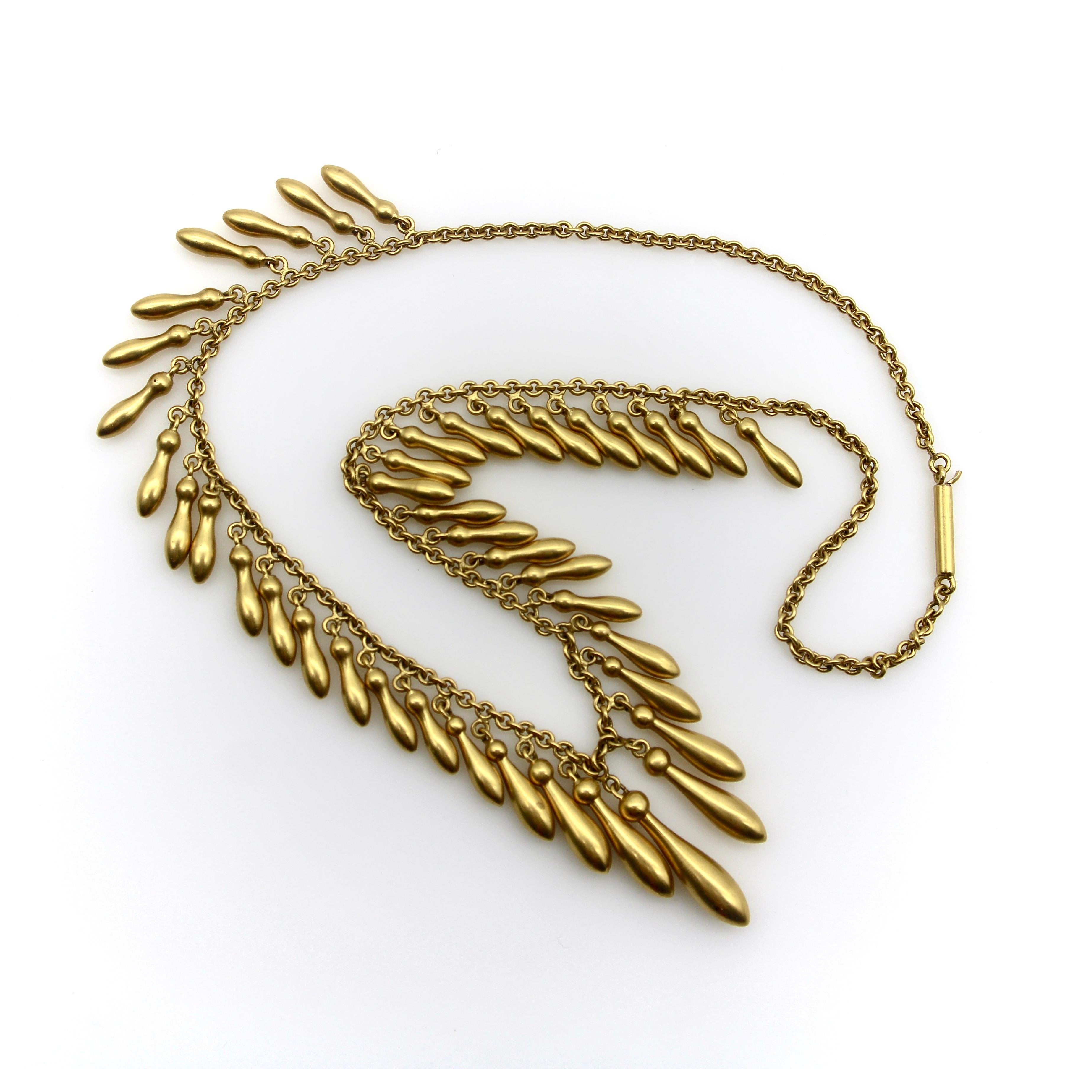 This 14k gold fringe necklace encapsulates the essence of romantic jewelry from the Victorian era. Graduated elongated drops topped with round spheres dangle from the 15” necklace. The gorgeous surface of the gold is what is known as a bloom