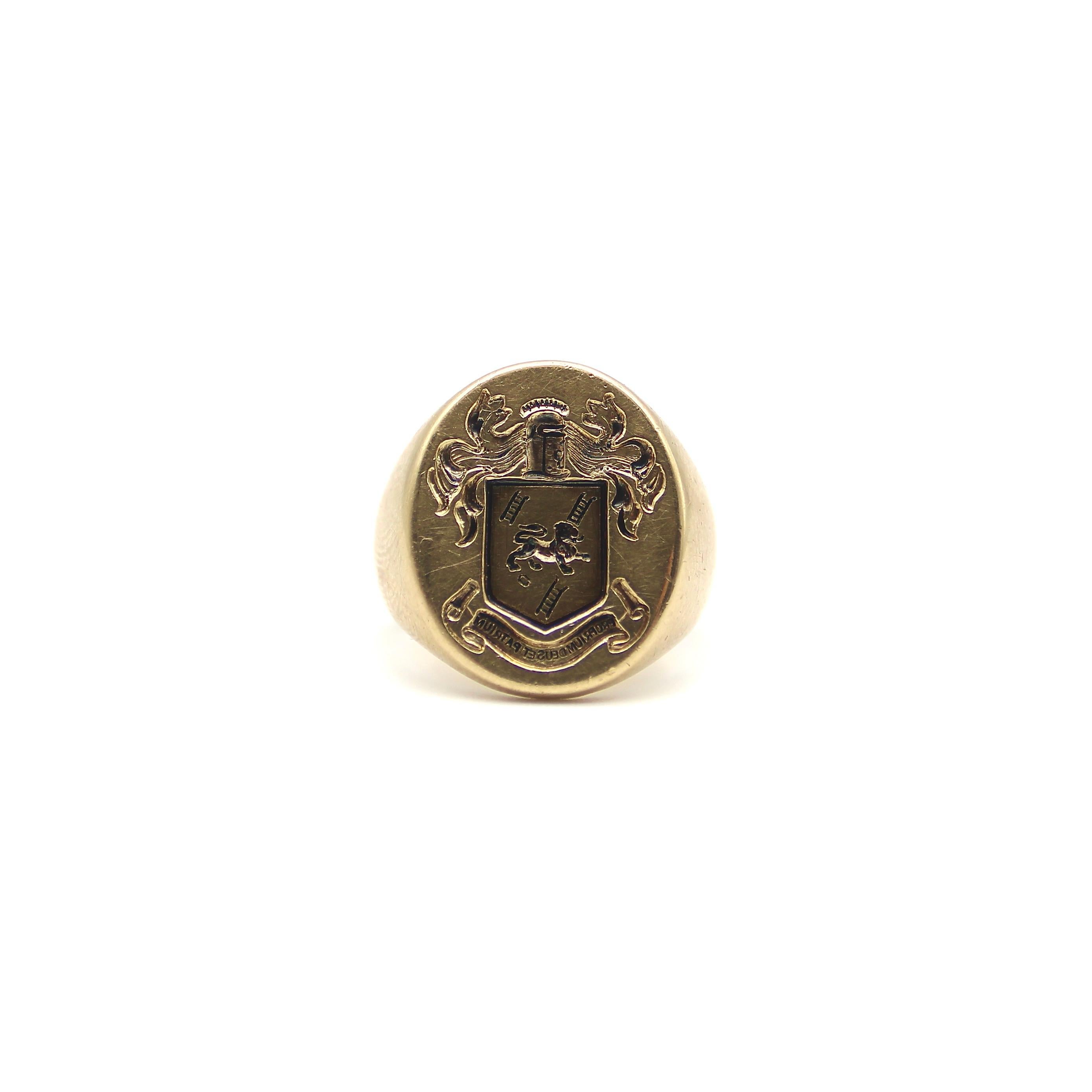 This is a powerful 14k gold signet ring circa 1900. The signet is carved in wonderful detail and complex imagery. In the center is a shield with a prancing lion amidst a background of three ladders. Above the shield is a knight’s helmet with a