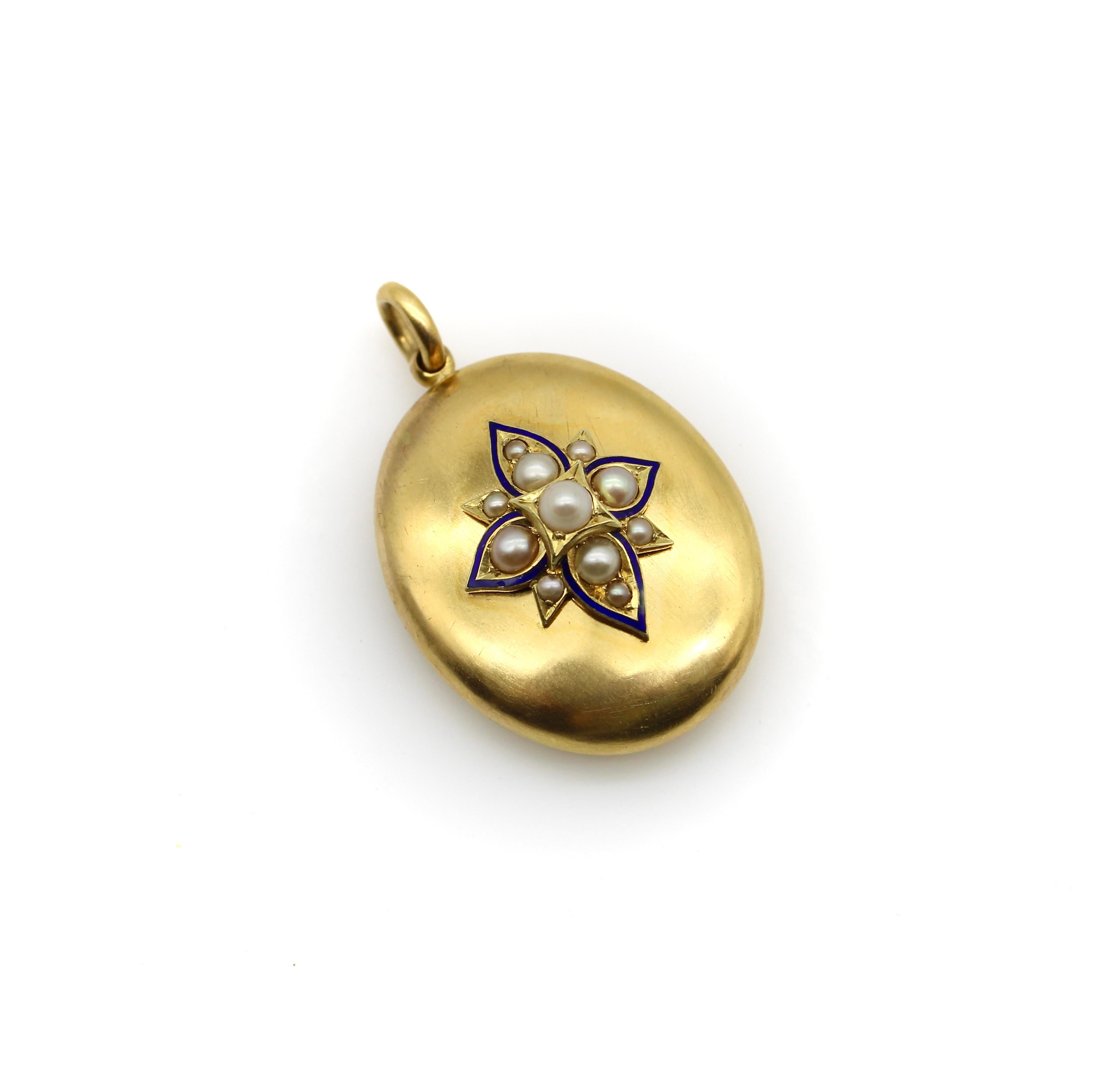 Circa the 1870’s or 1880’s, this 14k gold Victorian locket features a pearl quatrefoil flower element as its centerpiece. The floral adornment consists of 11 pearls delineated by a thin line of blue enamel. The quatrefoil has hand-engraved places