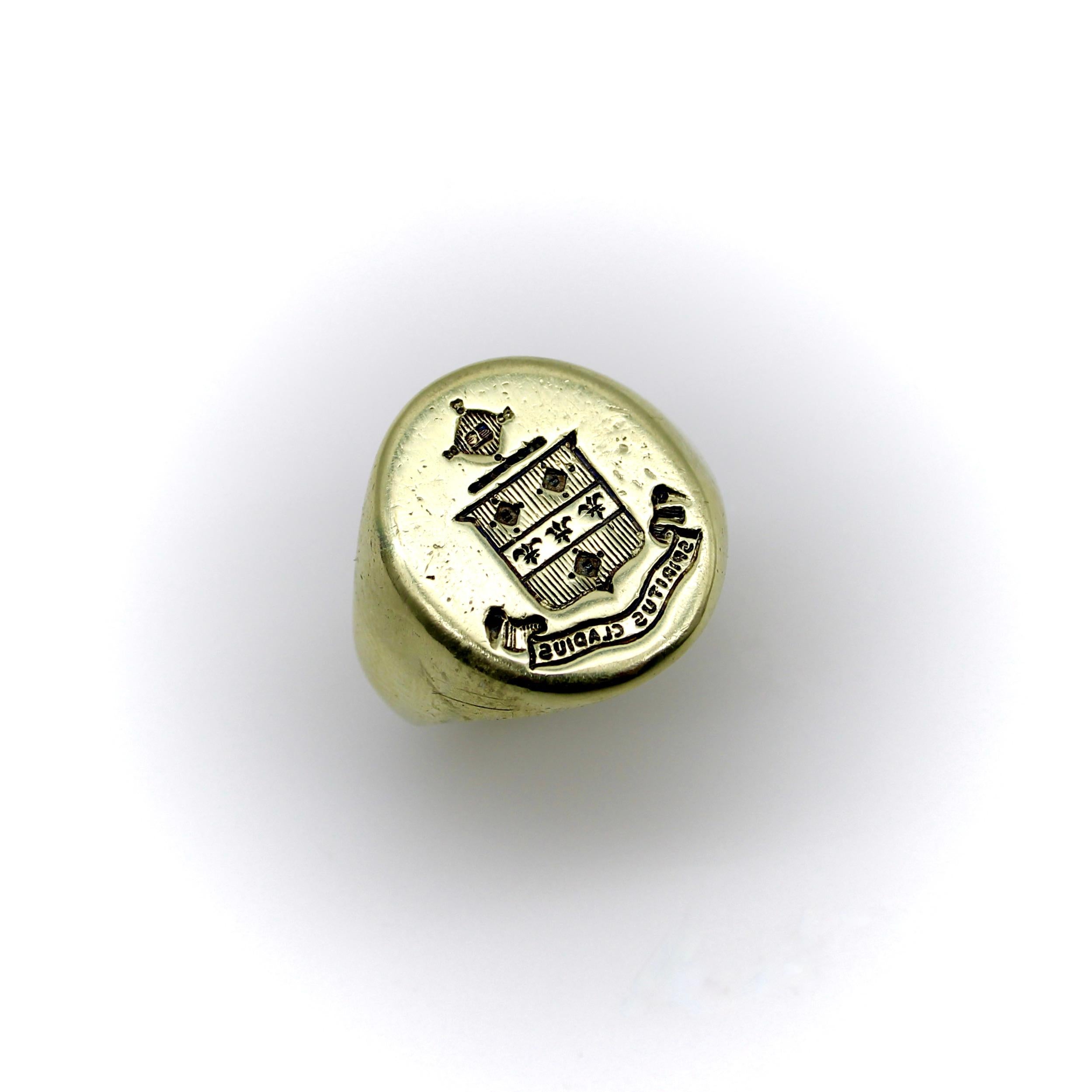 This 14k gold signet ring features a family crest of a shield topped with a radiating cross. The shield is divided into three sections, with vertical lines across the top and bottom sections, and a row of fleur-de-lis across the center. Above the