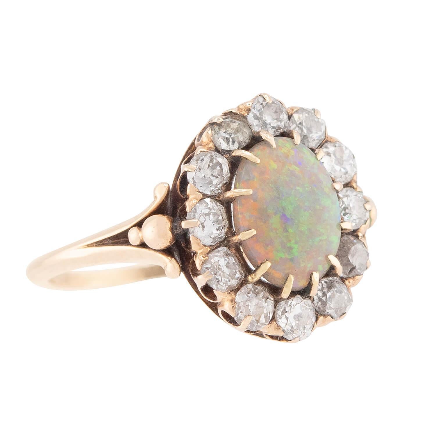 Un anello mozzafiato con opale e diamanti del periodo vittoriano (ca. 1880)! Questo bellissimo anello è realizzato in oro giallo 14 carati e contiene uno splendido opale cabochon incastonato al centro. L'opale è semplicemente ipnotico e presenta