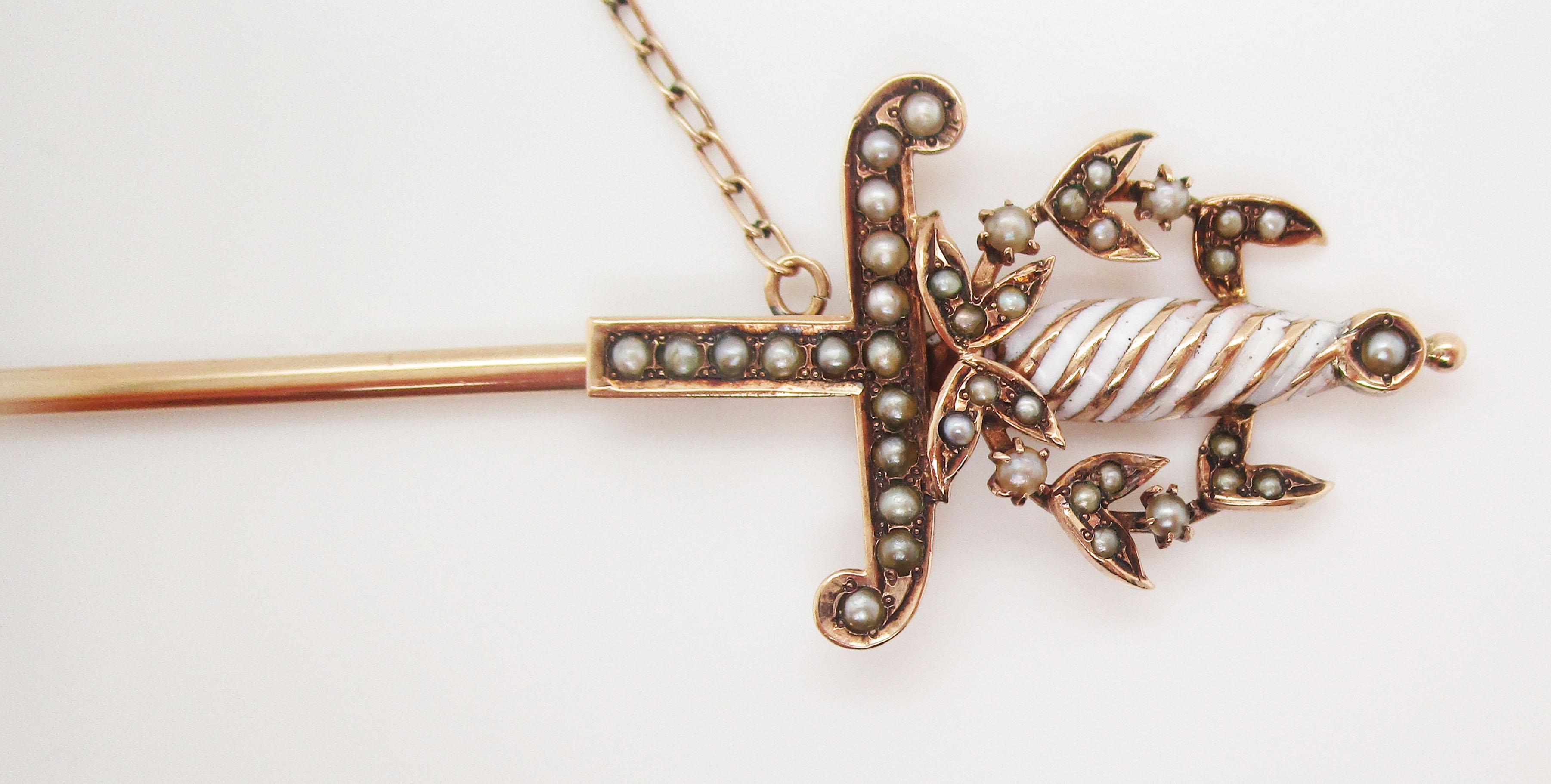 This stunning piece of Victorian artwork takes the shape of a jabot pin in 14k rose gold with an elegant sword design detailed with beautiful seed pearls. The pin itself is a miniature sword, it’s half scabbard the protective end of the jabot pin.