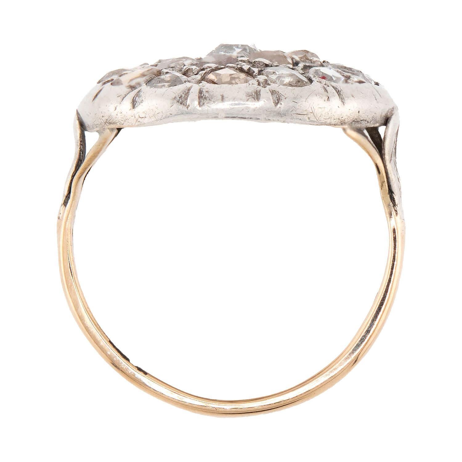 An absolutely lovely diamond cluster ring from the Victorian (ca1880s) era! Crafted in 14k gold and topped in silver, this ring features 21 rose cut diamonds, which are arranged to represent a blooming flower. All of the diamonds are held in place