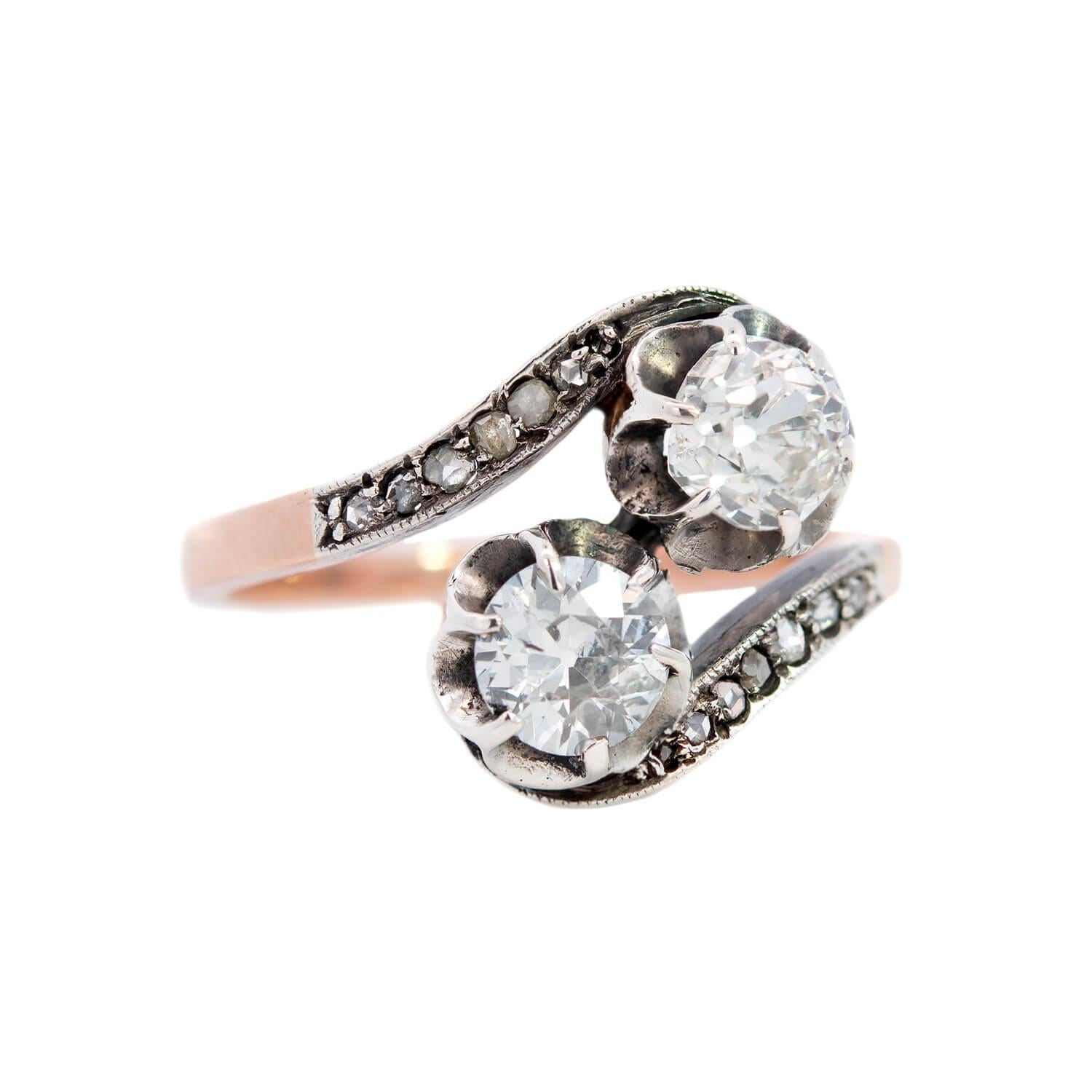 A diamond bypass ring from the Victorian (ca1850’s) era! Crafted in 14K yellow gold and silver topped this lovely piece features two old Mine Cut diamonds nestled together at the center, forming a stylish 