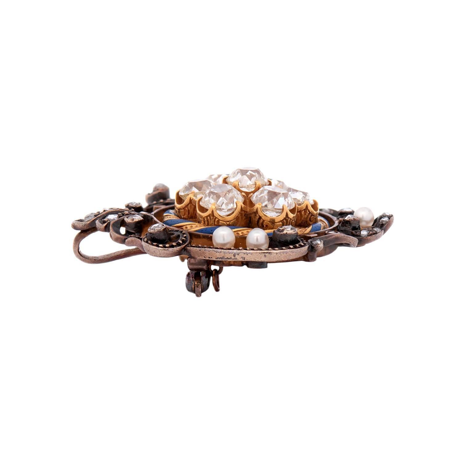 A stunning diamond and pearl brooch from the Victorian (ca1880) era! Crafted in 14k gold and sterling silver, this piece features a central cluster of seven diamonds, weighing a collective 4ctw. Surrounding the diamonds is a twisted enamel design in