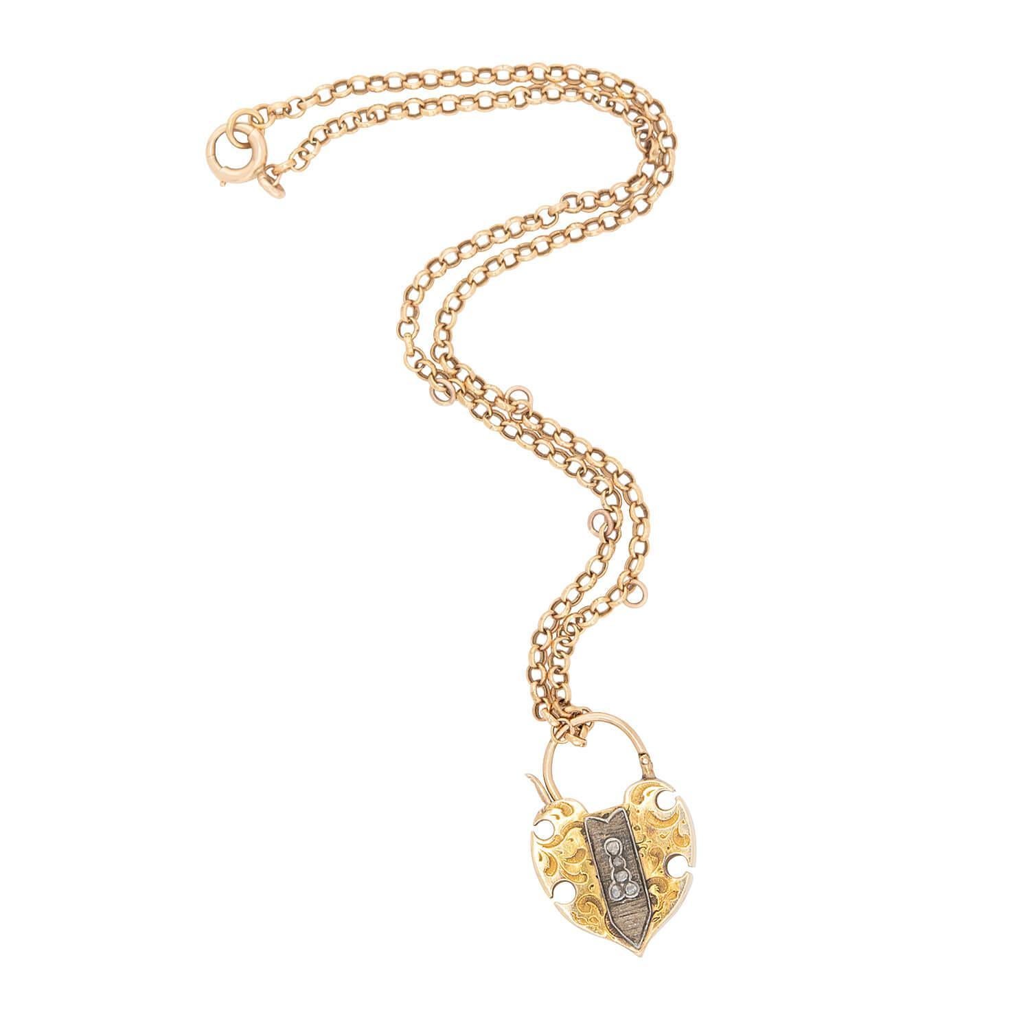 Una bellissima collana con ciondolo in oro di epoca vittoriana (ca. 1880)! Realizzata in oro giallo 14k e argento sterling, questa collana è caratterizzata da un ciondolo a forma di cuore a lucchetto, con un grande granato centrale dal taglio ovale.