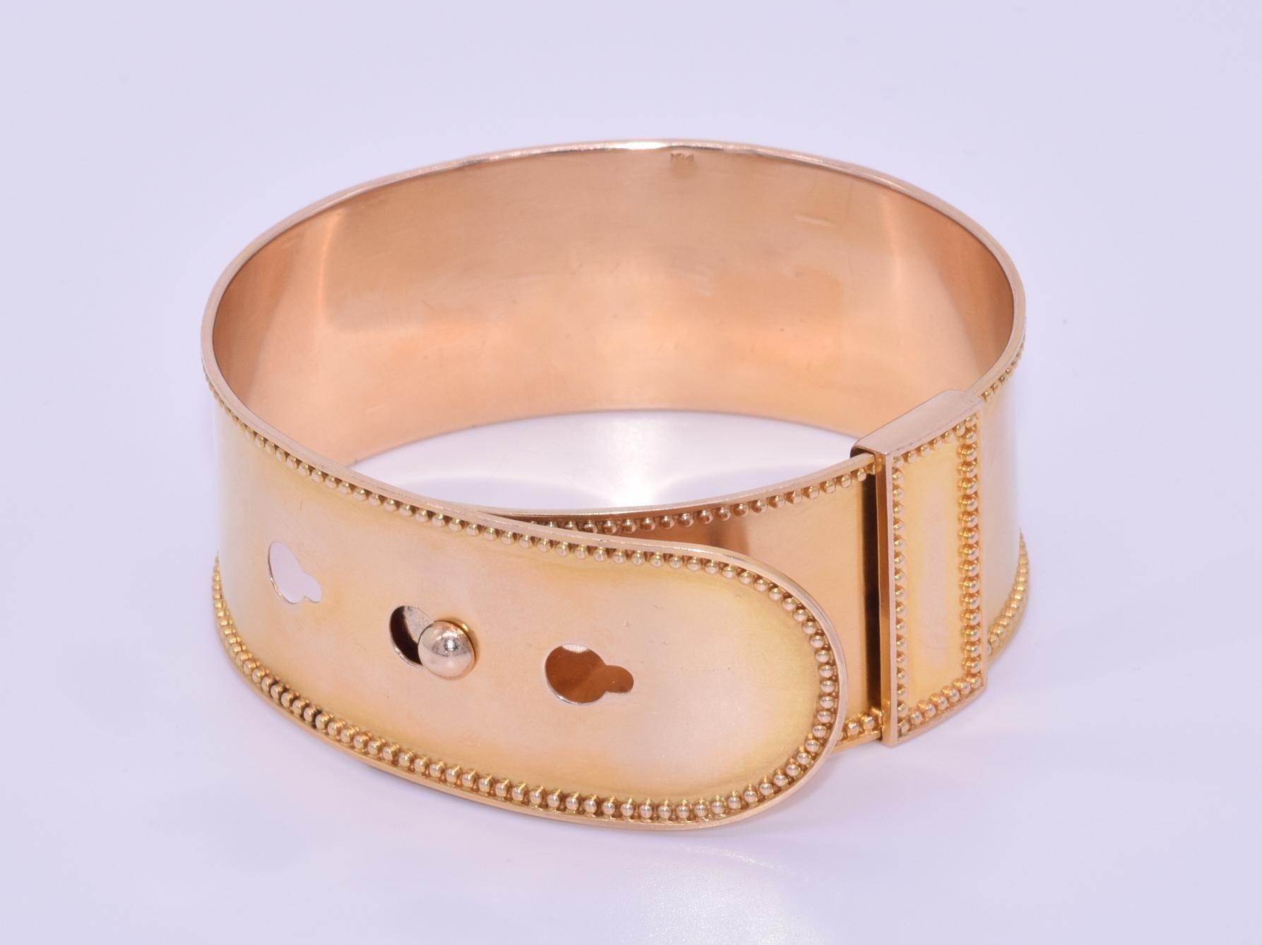 Victorian 14 Karat Yellow Gold Buckle Adjustable Bangle Bracelet, circa 1880s

An adjustable bangle with gold beadwork border detail is formed of 14 karat yellow spring gold with a sliding bar fastener and 3 sizing options. The cuff measures
