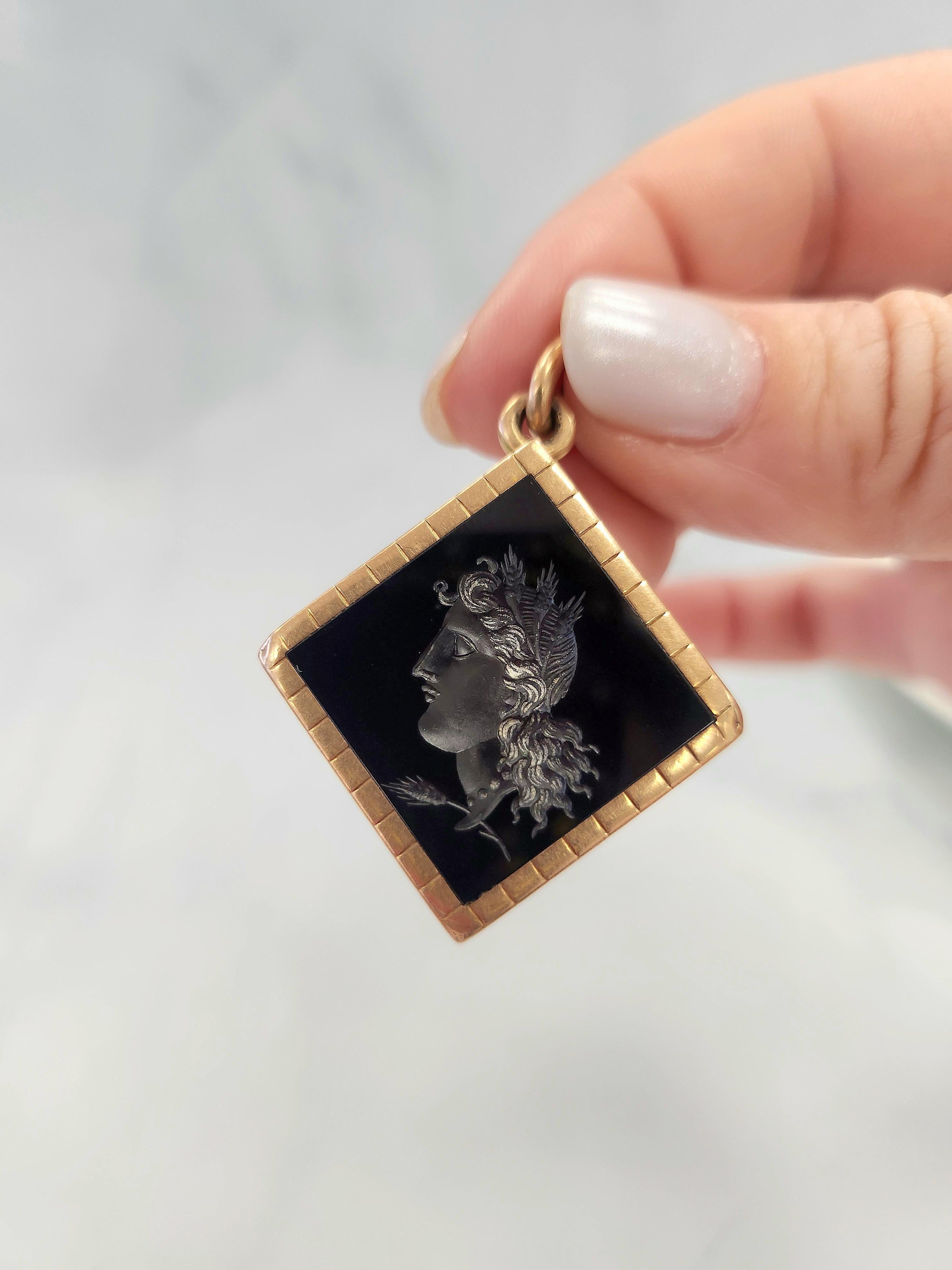 Victorian circa 1880s
Carved carnelian intaglio pendant set in 14k yellow gold.
Diamond shaped deep red/brown colored carnelian carved with an image of a young man's portrait
24mm length (~1 inch) 7.5mm width diamond shape gold frame opens as a