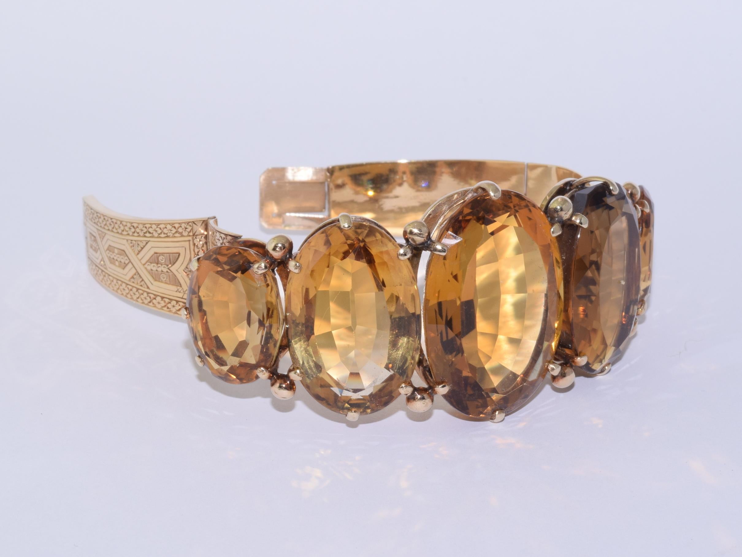 Five oval citrines totaling approximately 135 carats are set atop an engraved hinged 14 karat yellow gold cuff.   

Inner circumference, 6.25 inches. Width at top, 1-3/8 inches. Width at bottom, 1/2 inch.
