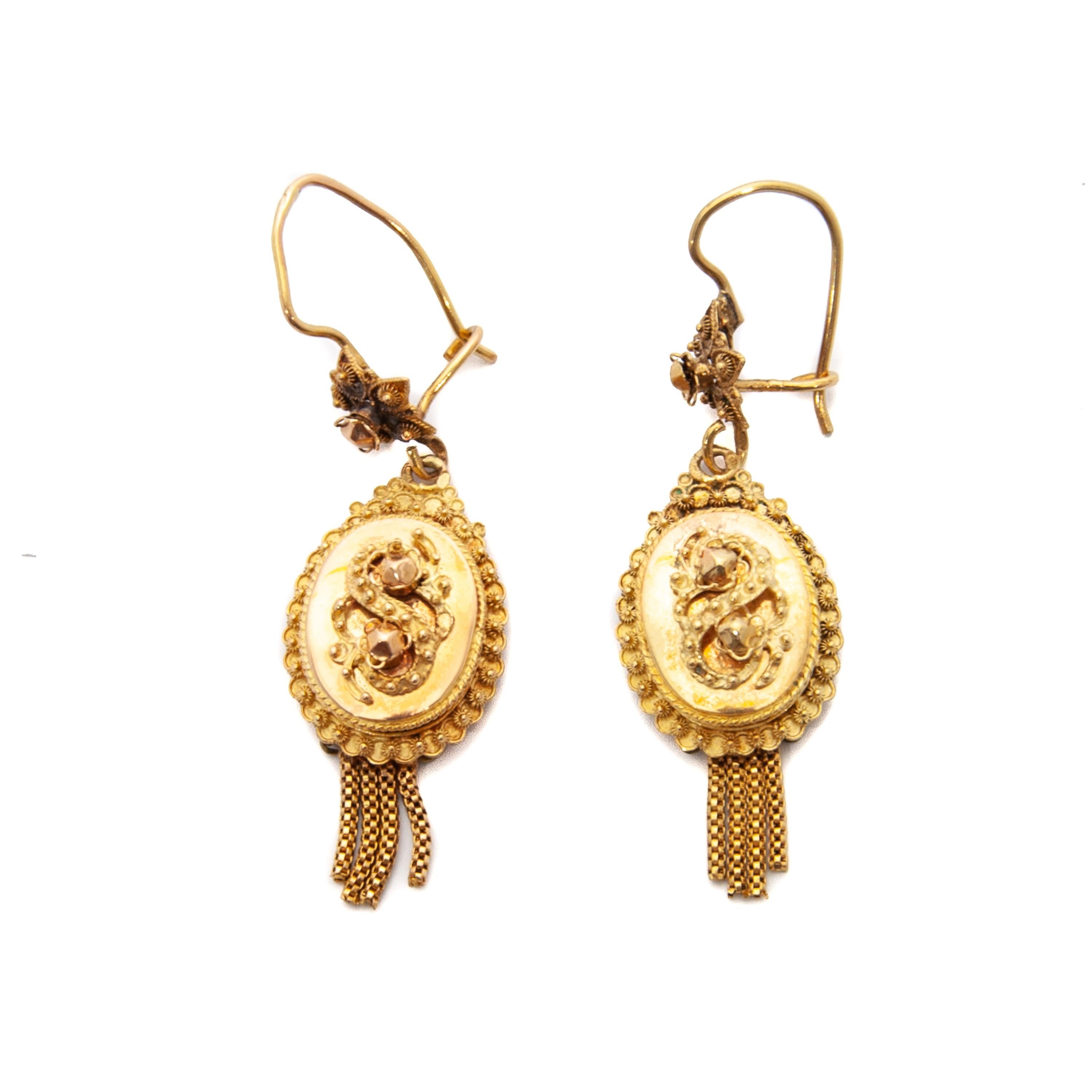 Gorgeous Victorian 14 karat yellow gold oval-shaped filigree drop earrings. The earrings consists of a S-shaped relief and adorned with rosette square knots. The border of these lovely earrings have a scalloped edge embellished with small filigree