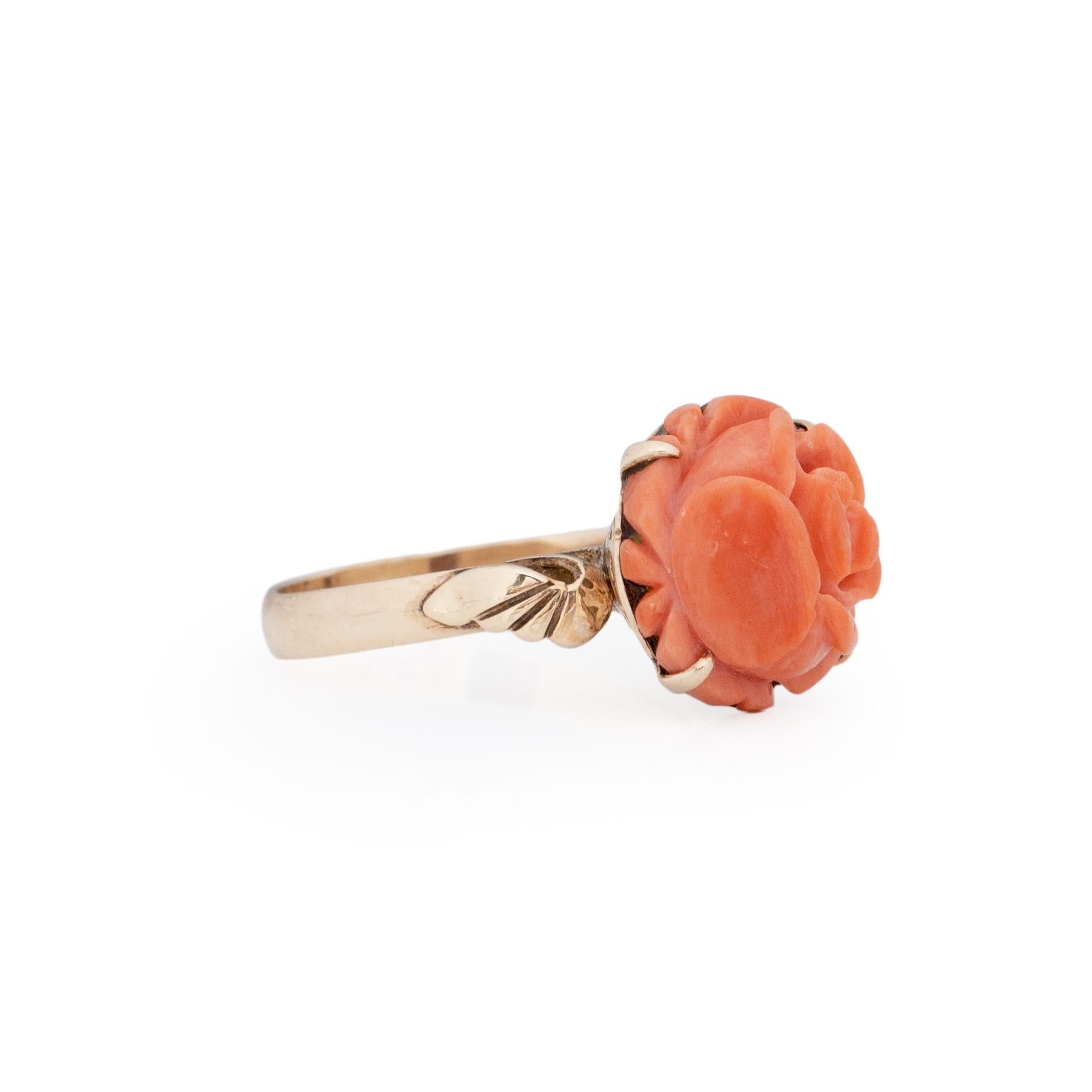 Looking for a flower that will never die? This unique treasure is perfectly hand made. Crafted in 14K yellow gold from the leaf details on the shoulders, to the scroll work in the gallery. This peachy colored coral rose is a work of art. The hue of