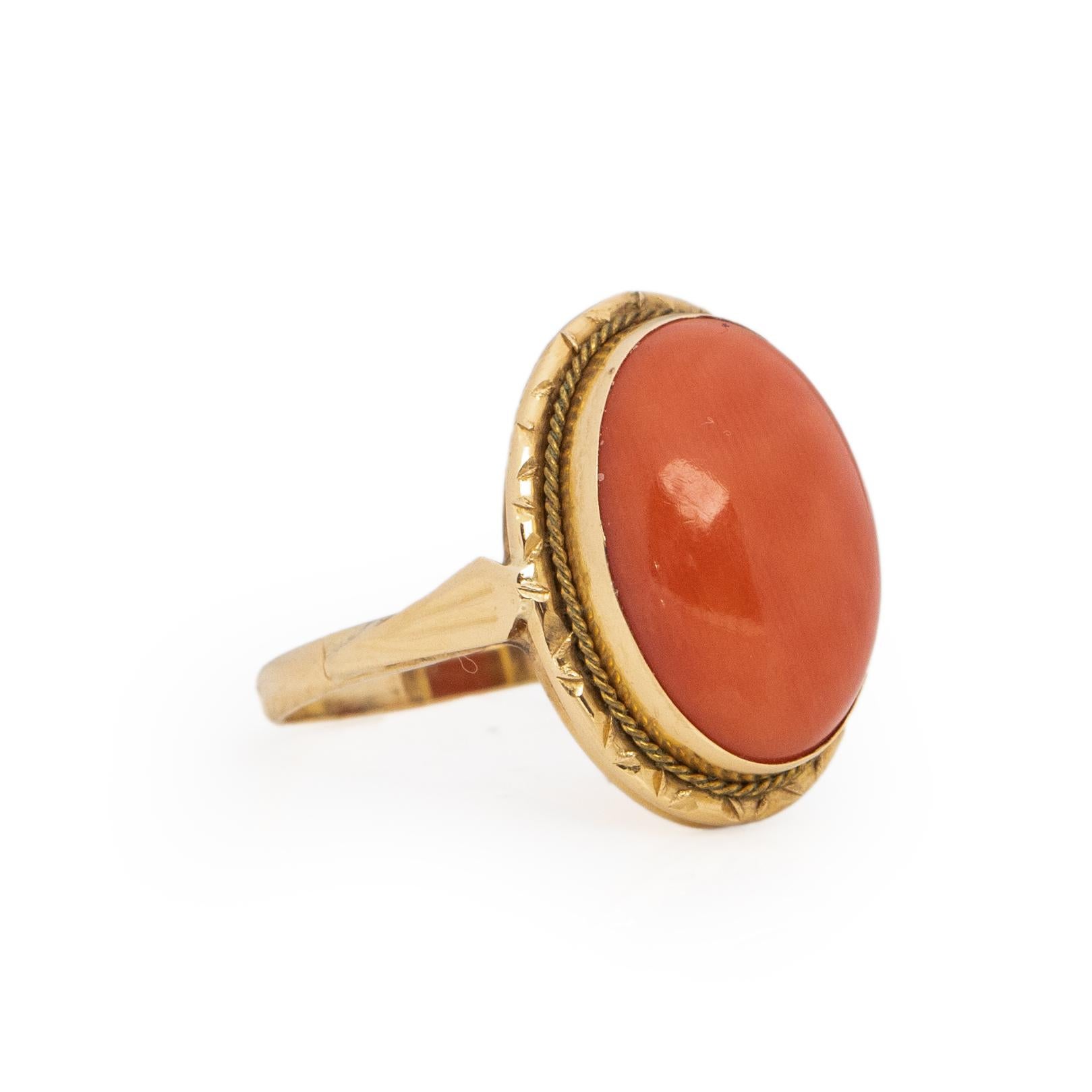 Here we have a beautiful coral cabochon ring. crafted in 14K yellow gold. The smooth oval cab is a breathtaking orange coral, a great pop of color. The yellow gold us a excellent compliment to the orange hue of the coral. Surrounding the bezel