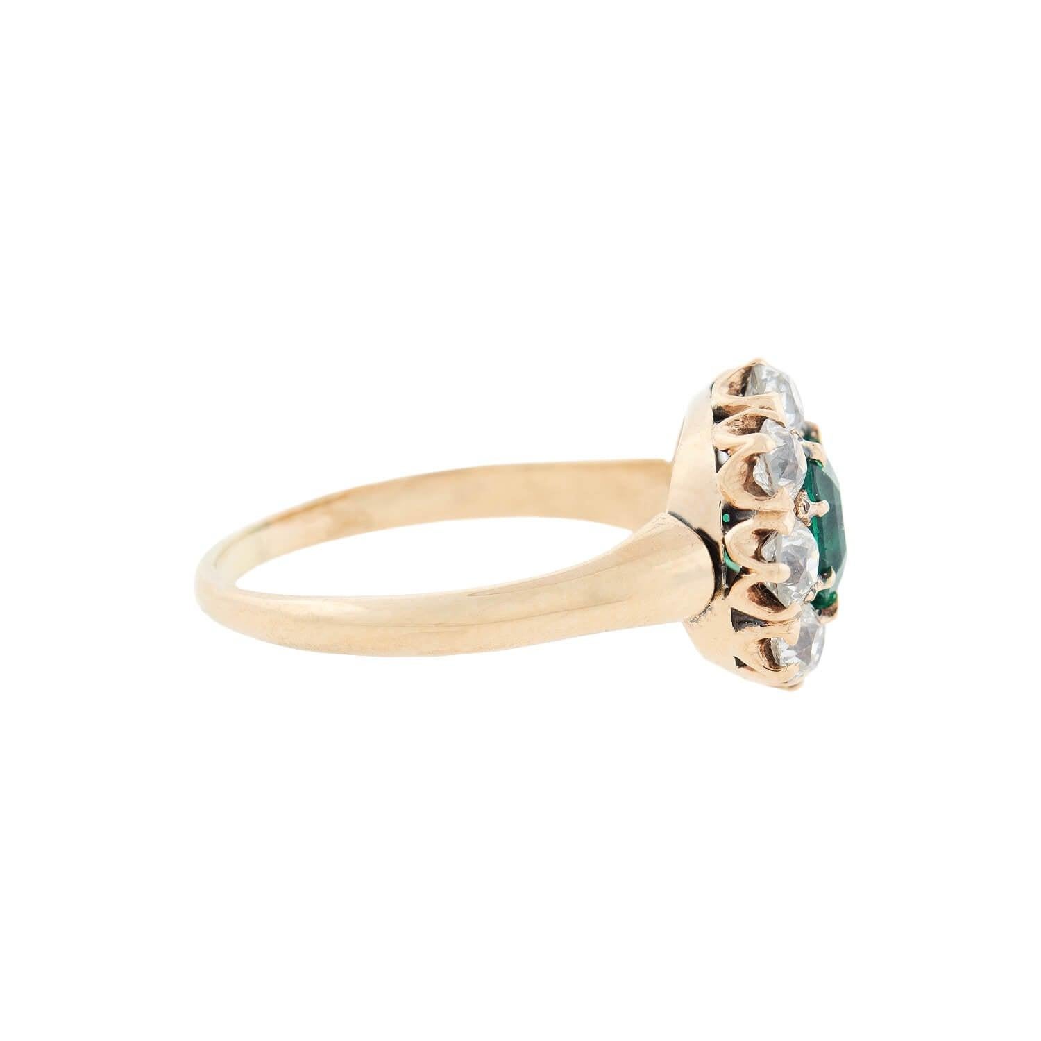 A stunning emerald and diamond ring from the Victorian (ca1880s) era! Crafted in 14kt yellow gold, this lovely piece is comprised of a vibrant Asscher Cut emerald stone surrounded by 8 sparkling Old Mine Cut diamonds for a lovely cluster effect. The