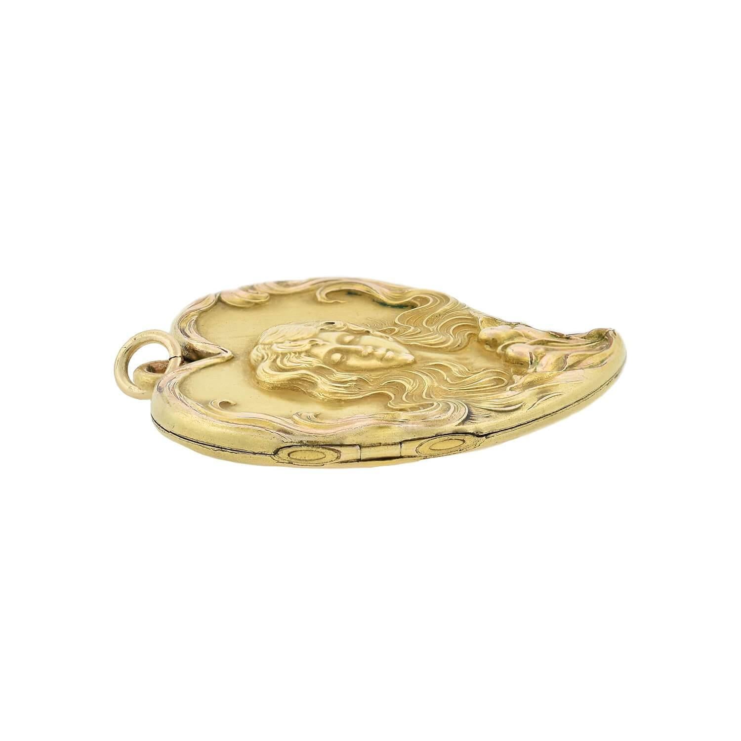A stunning pendant from the Victorian (ca1890s) era! Crafted in 14kt yellow gold, a maiden adorns the top of this Witch's Heart locket. Her hair curls to create the heart's border, and two flowers sprout from the tip of the heart. The flowers may be