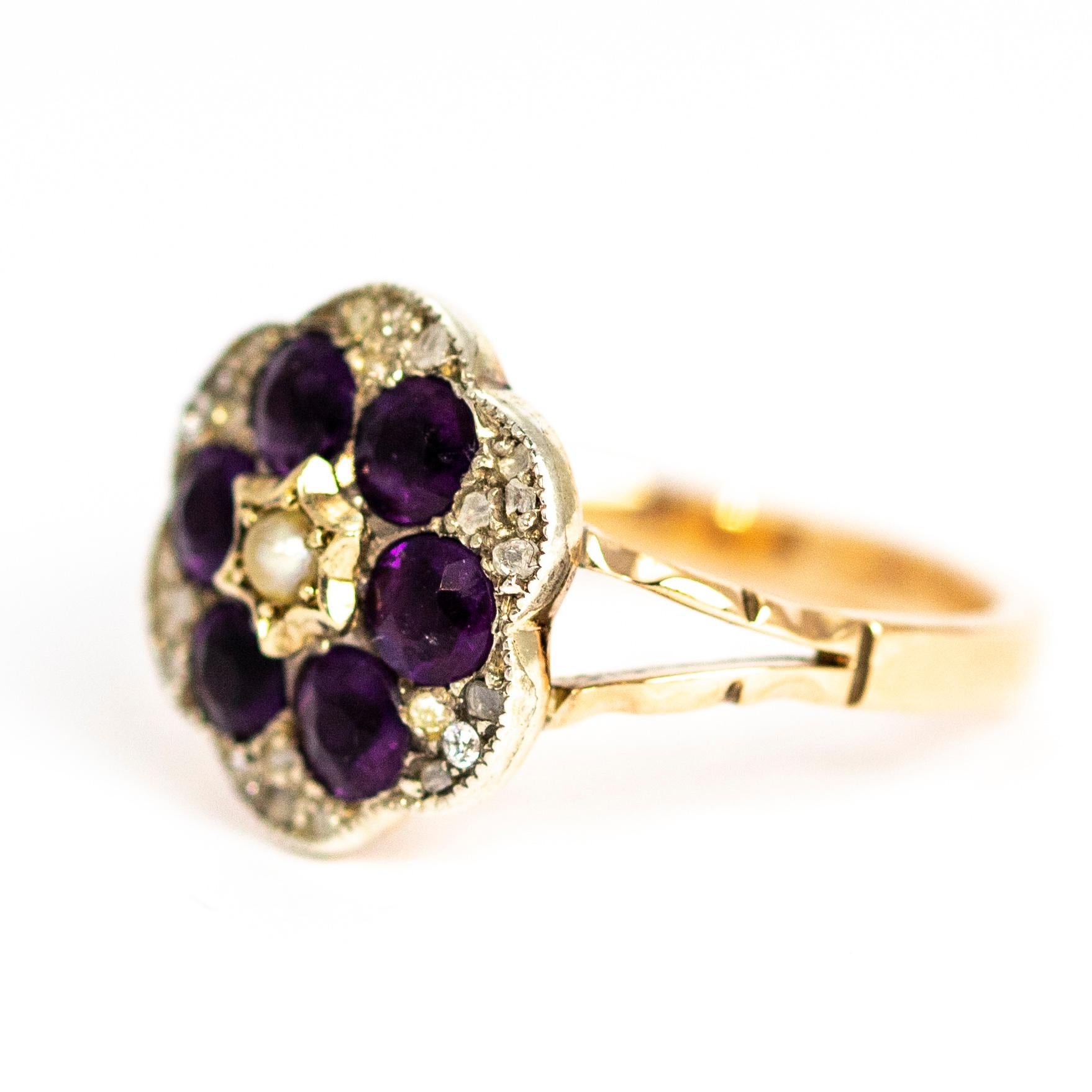 A wonderful antique early Victorian cluster ring. Centrally set with a seed pearl, surrounded by six stunning deep purple round-cut amethysts, foiled to enhance their colour. Between the amethysts in the scalloped front are six groups four white