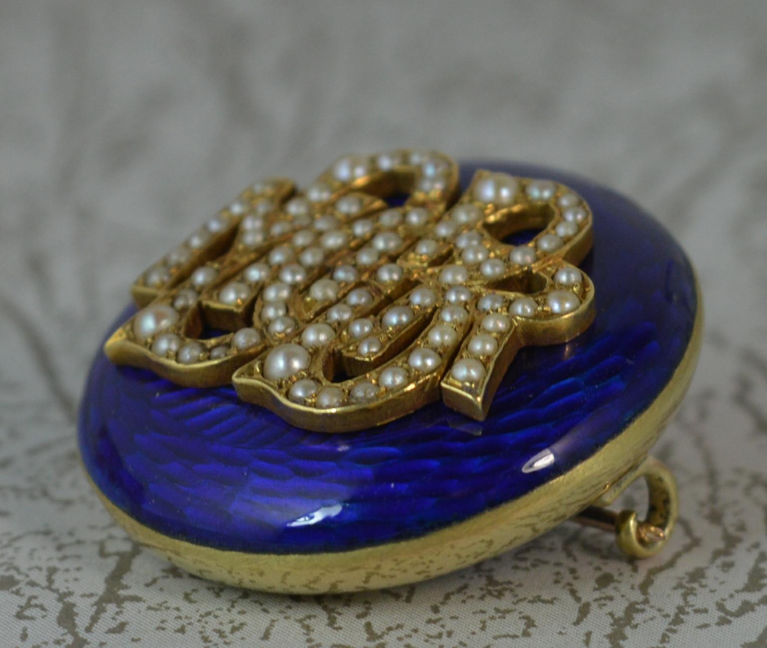 A mid to late Victorian period circular brooch. 15 carat gold example. Mourning design with locket section to reverse. Designed with DB MOR encrusted with seed pearls throughout and with a deep Royal blue enamel throughout the front.

Condition ;