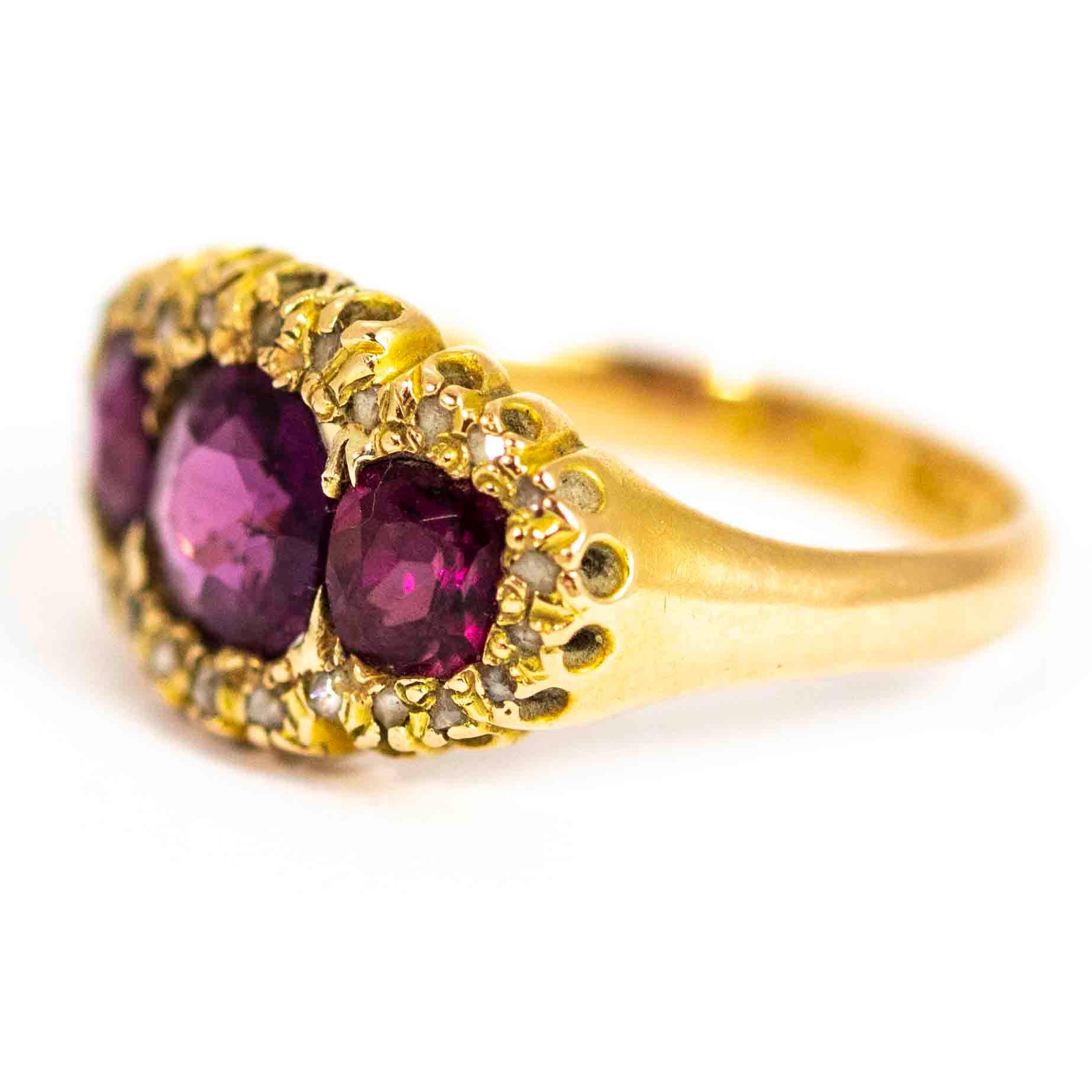 A beautiful antique victorian ring. Set with three wonderful cushion cut garnets surrounded by a large halo of 26 rose cut diamonds. Modelled in 15 carat yellow gold. Fully hallmarked 1874 Birmingham, England.

Ring Size: UK O, US 7