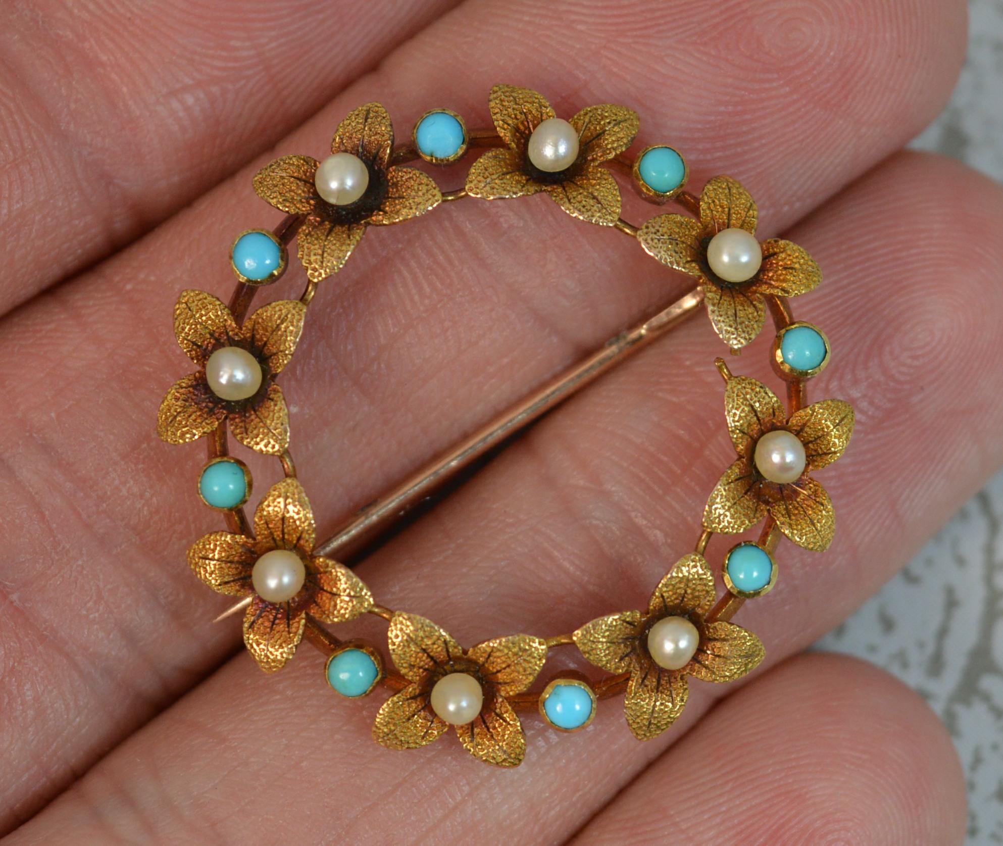 A superb quality late Victorian era brooch. Solid 15 carat gold example. Circular wreath like shape formed with flowers set with pearls to the centre and turquoise in between. Very finely made piece.

Condition ; Very good. Crisp pattern. Working
