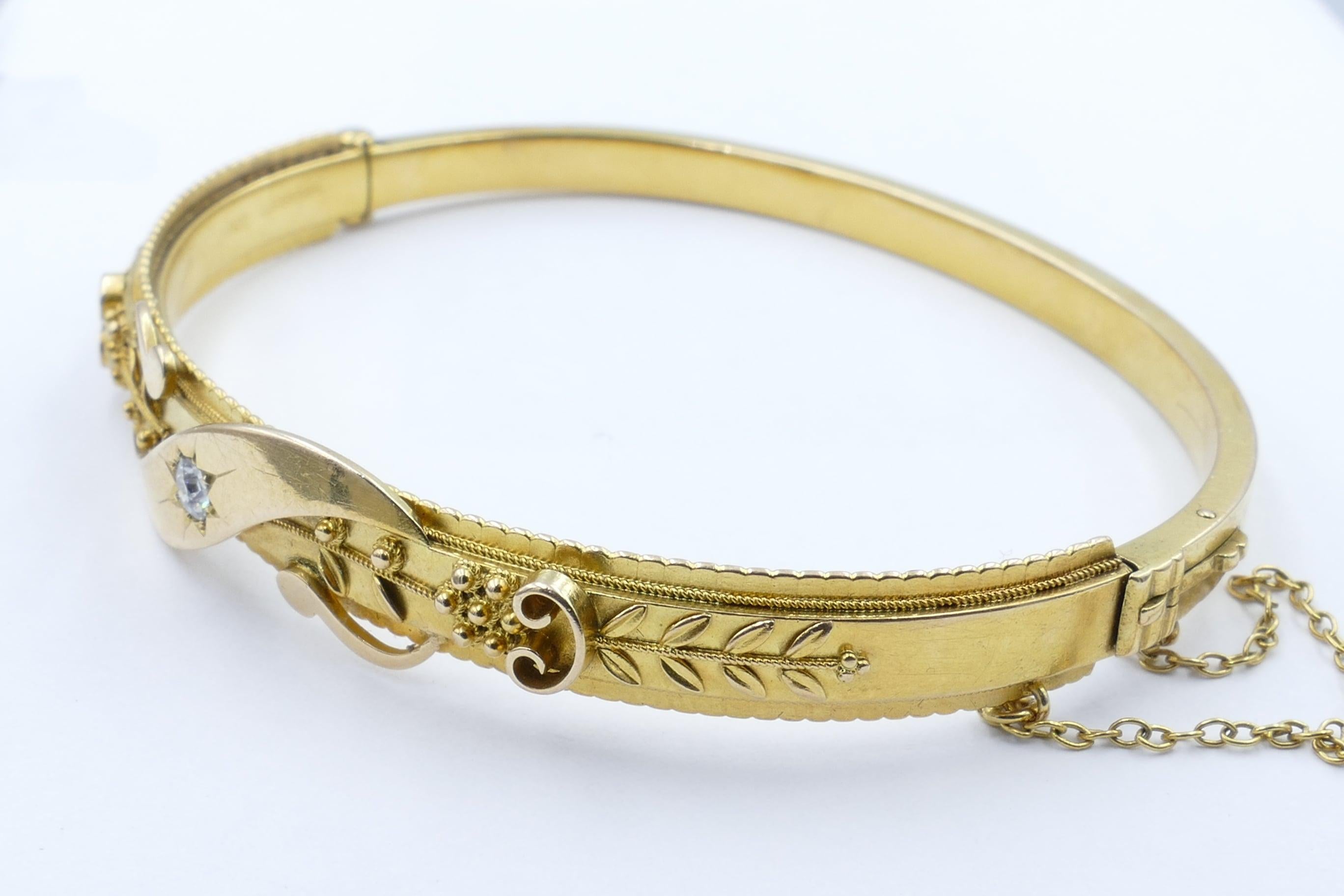 This 15ct Antique Yellow Gold Diamond Bangle features 1 Old European Cut Diamond of 0.12 Carat, Colour G, Clarity SI2, Bright Star Set.
This Bangle is Victorian, of English origin, with raised Foliage, Scrolling & Millegrain Detail.
It measures