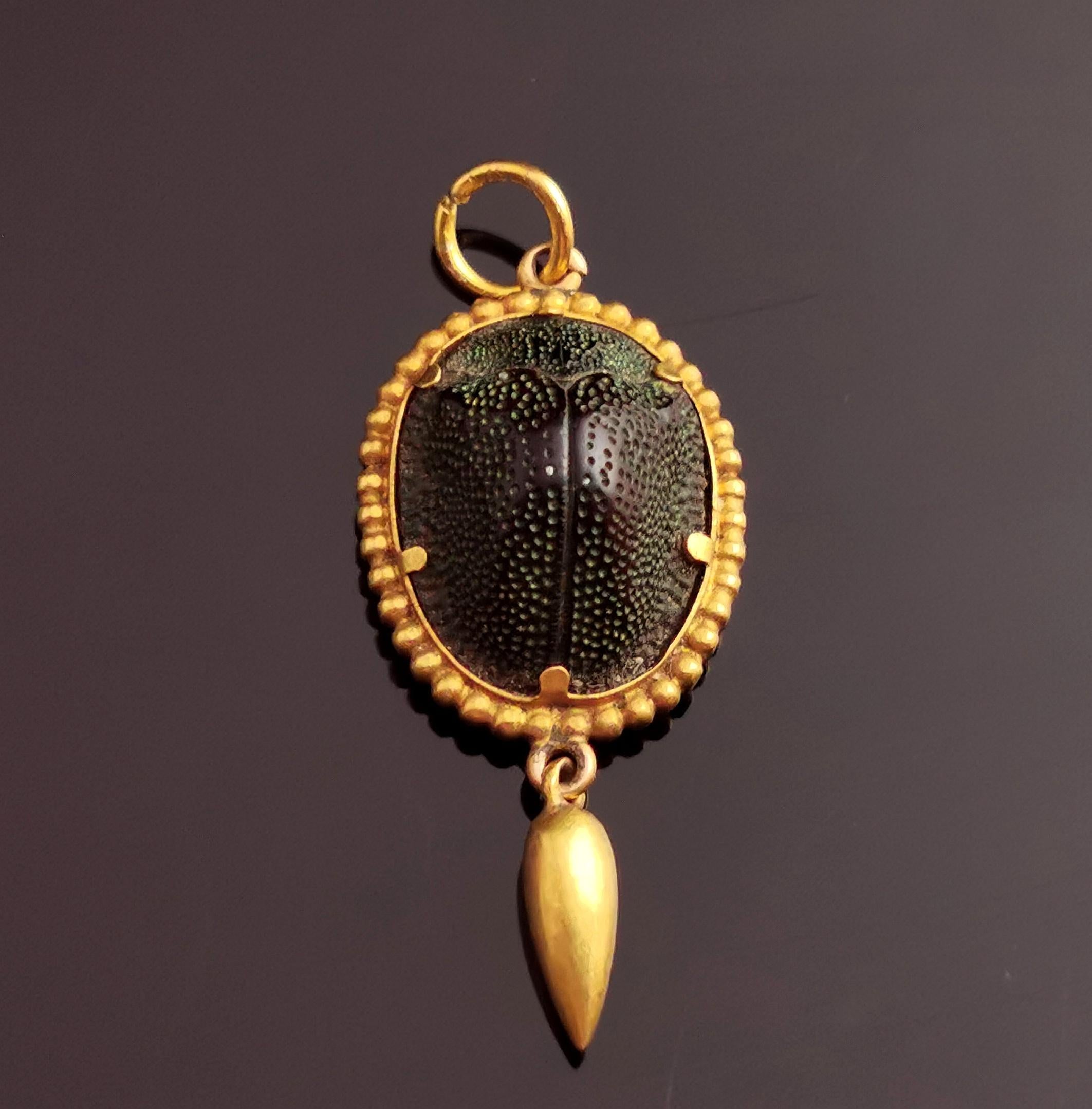 A beautiful antique Victorian scarab beetle drop pendant.

It is made from 15kt bloomed gold and houses a real iridescent green scarab beetle set into the beaded gold setting.

The pendant has an articulated drop which gives it a little movement and