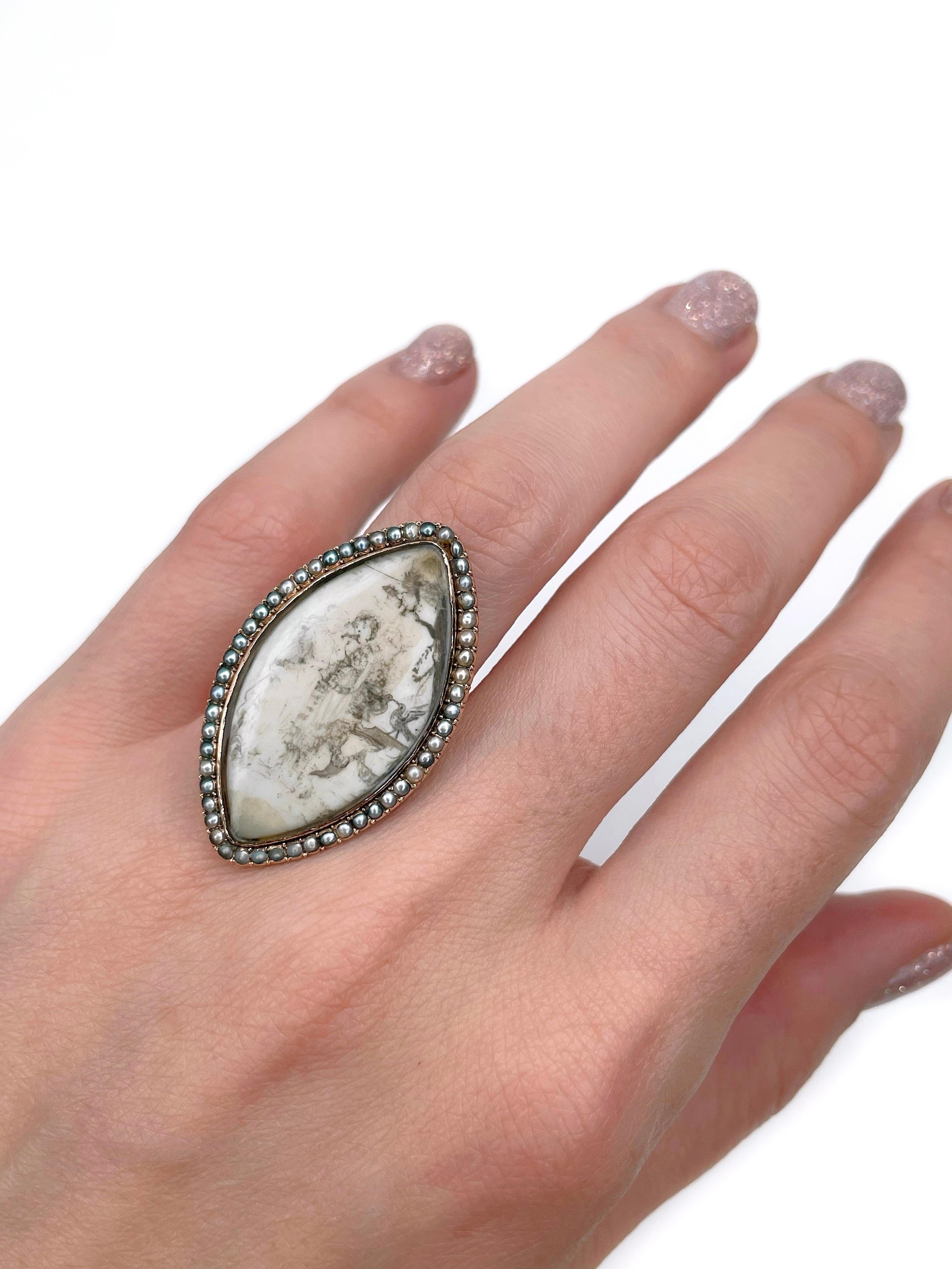 This is a Victorian navette ring crafted in 15K gold. Circa 1880.

It features a detailed miniature painting depicting two persons (possibly a couple) standing near two birds. The piece is adorned with seed pearls of different shades.

There is an
