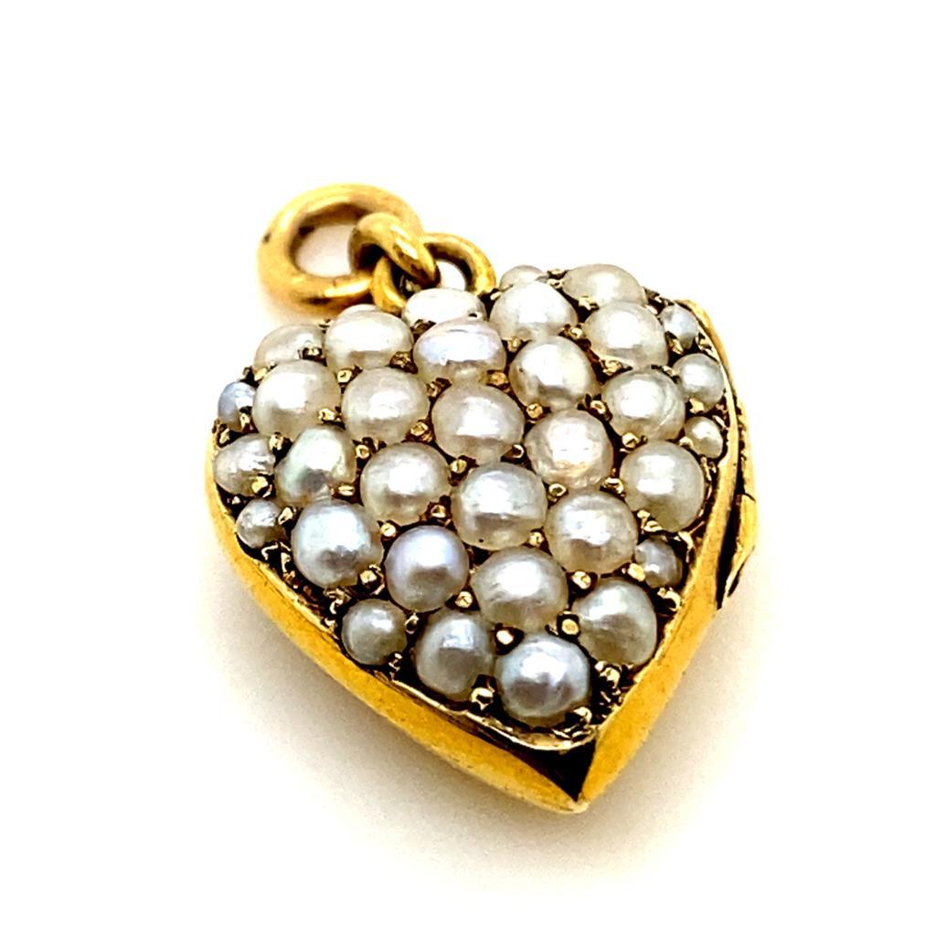 A Victorian 15 karat yellow gold seed pearl heart locket pendant.

This sweet heart shaped locket pendant, features thirty four claw set seed pearls to its domed front.

The heart locket is hinged and memorial glass is trimmed to fit inside one of