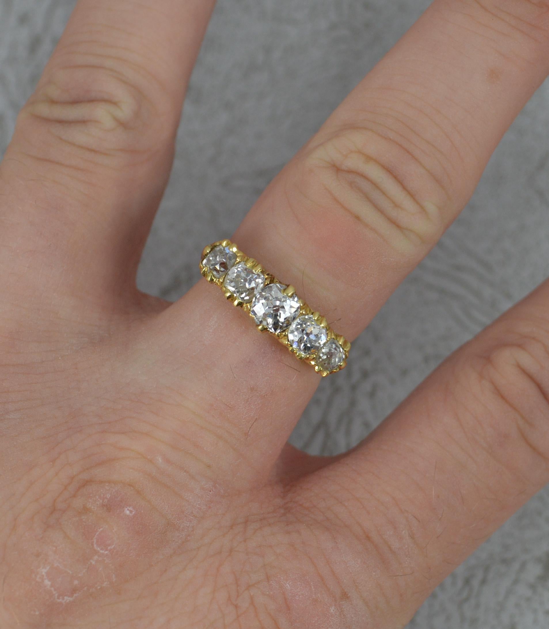 A stunning 18 carat gold and diamond five stone ring. c1890.
18 carat yellow gold example.
Designed with five natural old cut diamonds to total approx 1.50 carat of slightly graduated size. 19mm spread of stones. 5.7mm wide band to front. Protruding