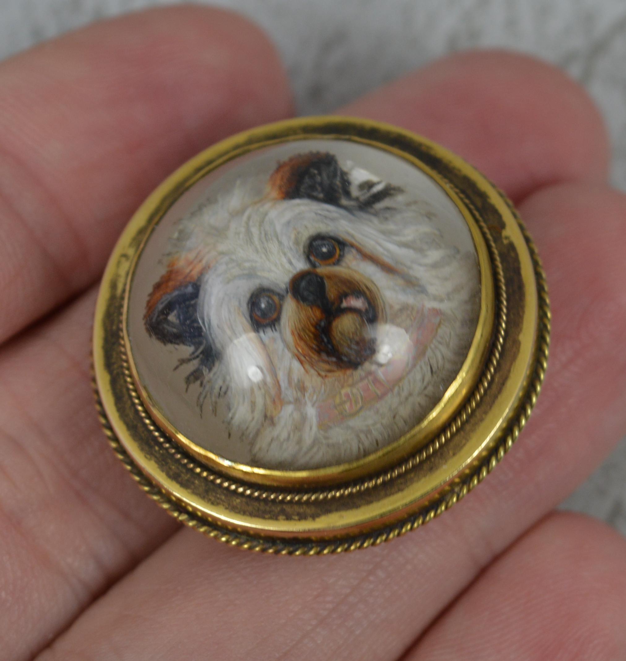 A stunning antique brooch circa 1860-70.
Solid 15 carat yellow gold example.
The circular example is set with an Essex crystal reverse intaglio hand painted image of a dogs head to centre. Superly well done. Simple gold border.

CONDITION ; Very